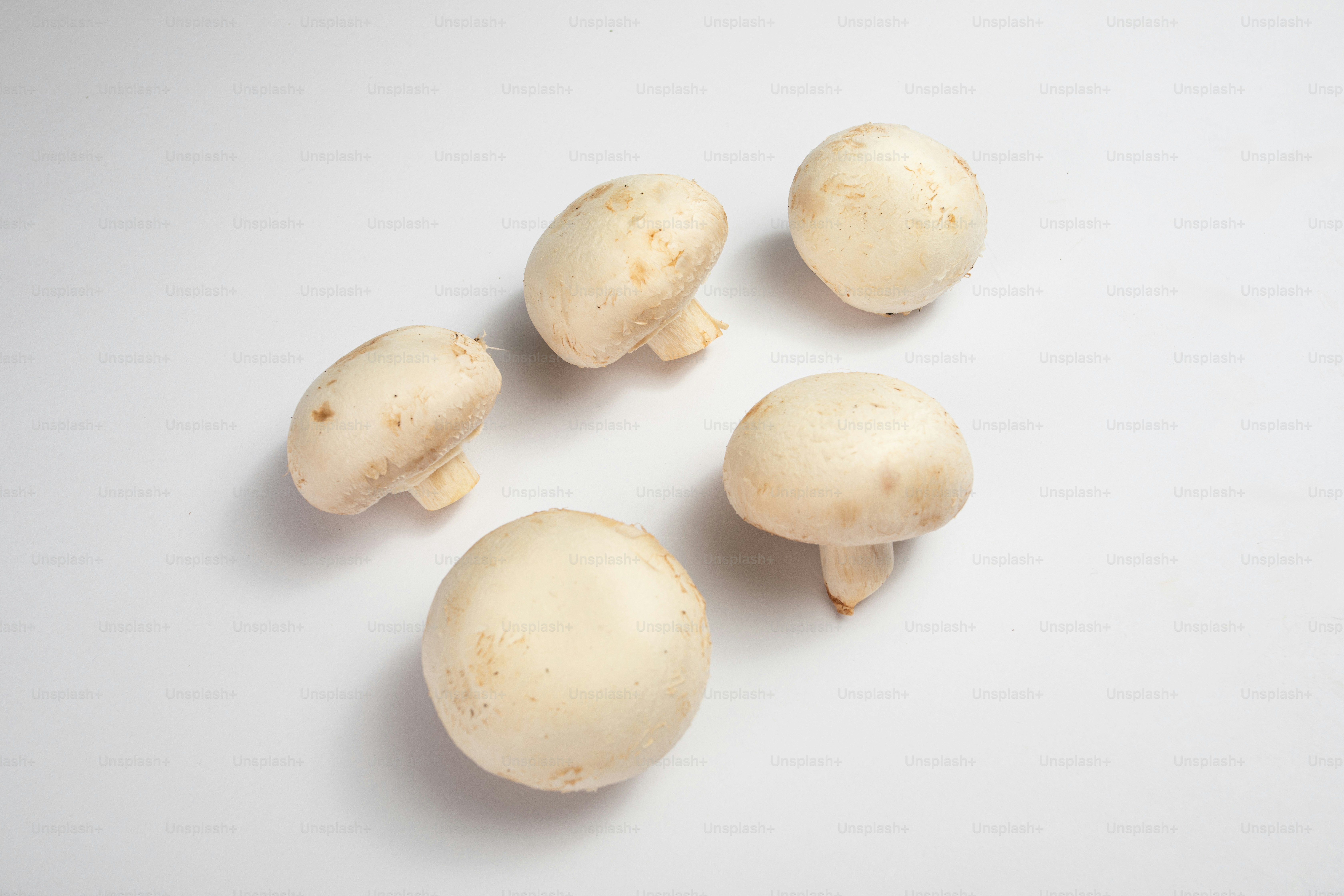 Un grupo de setas sentadas encima de una mesa blanca