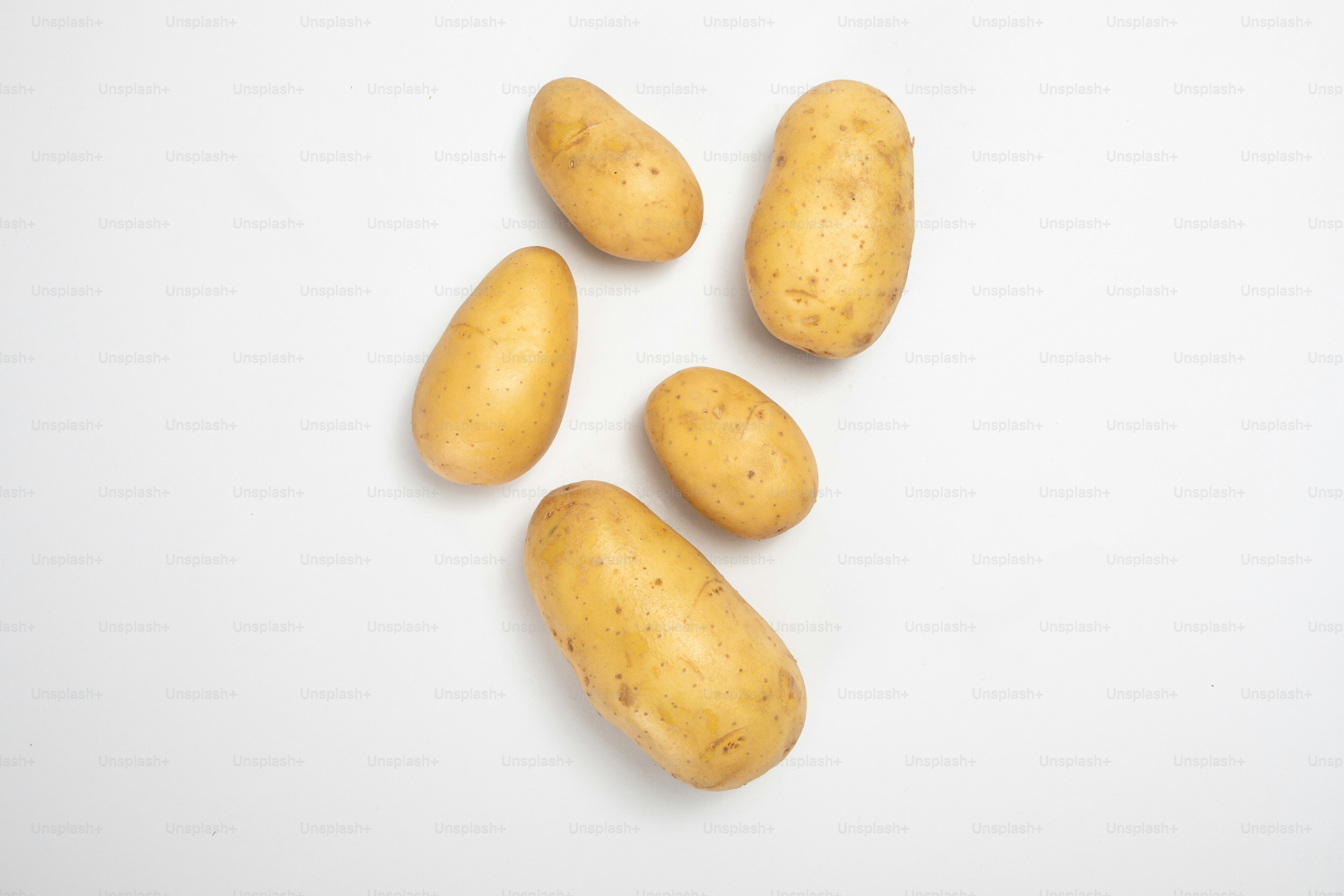 Un grupo de patatas sentadas encima de una mesa blanca