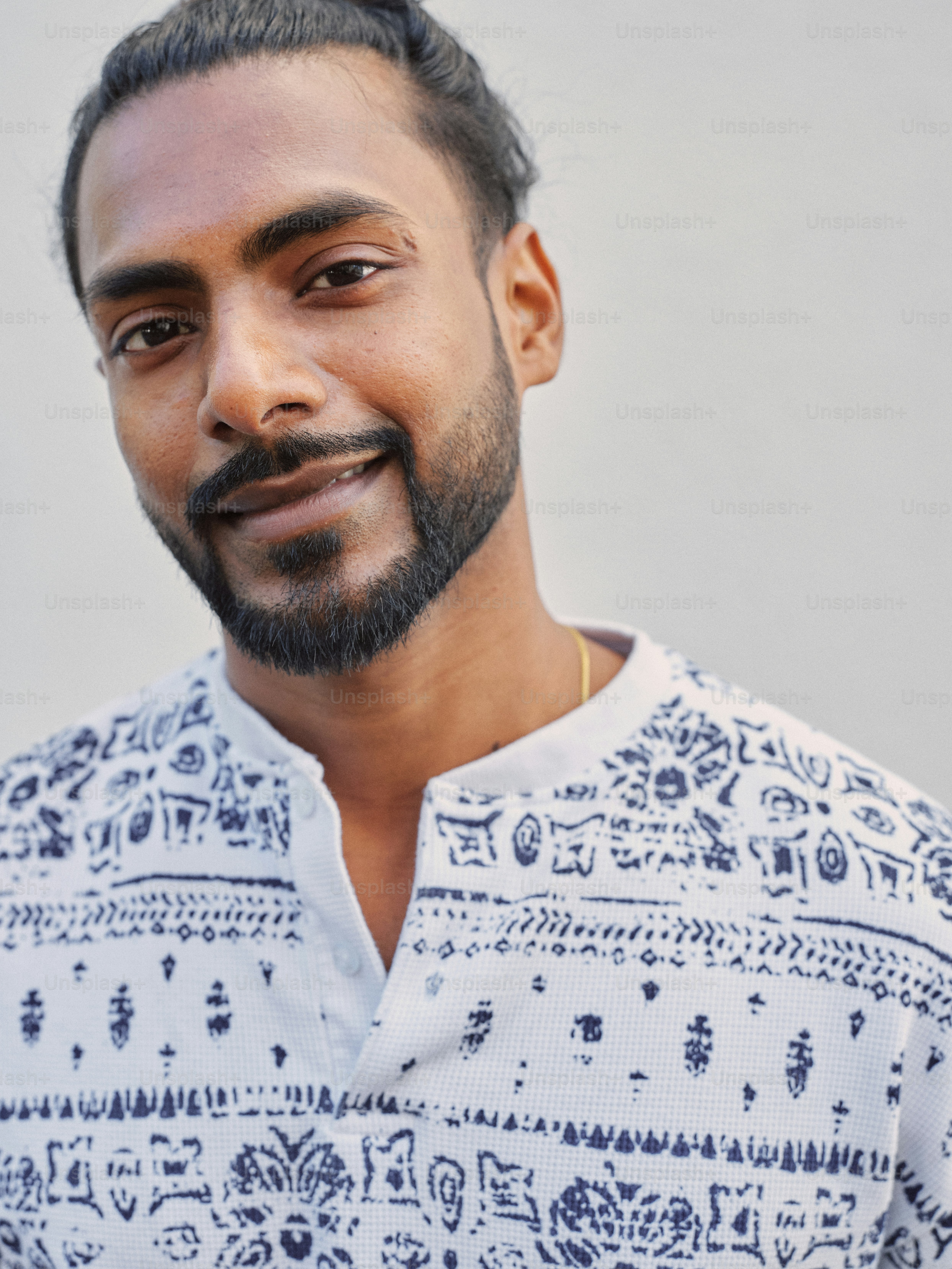 Un uomo con la barba che indossa una camicia bianca