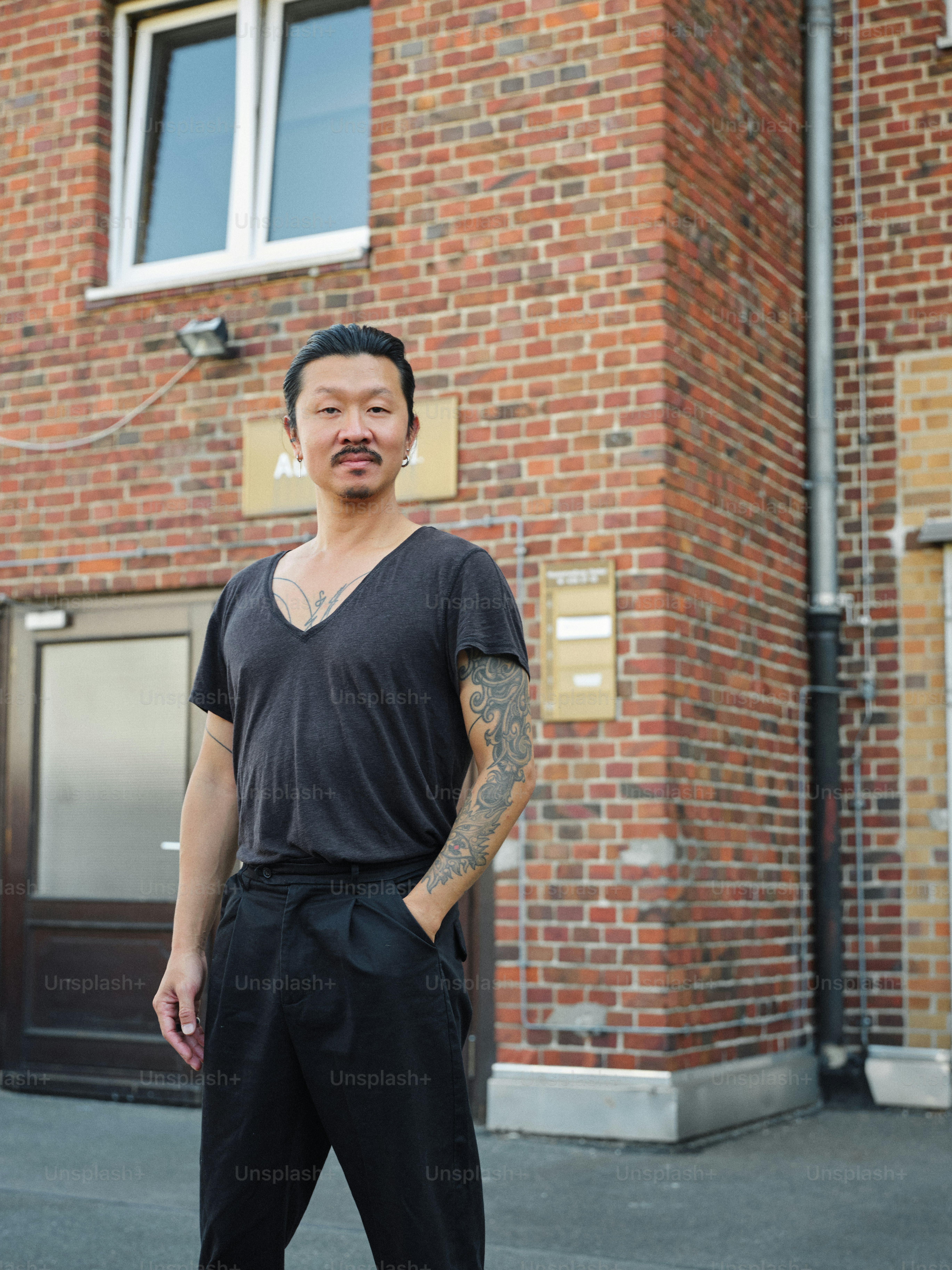 A man standing in front of a brick building