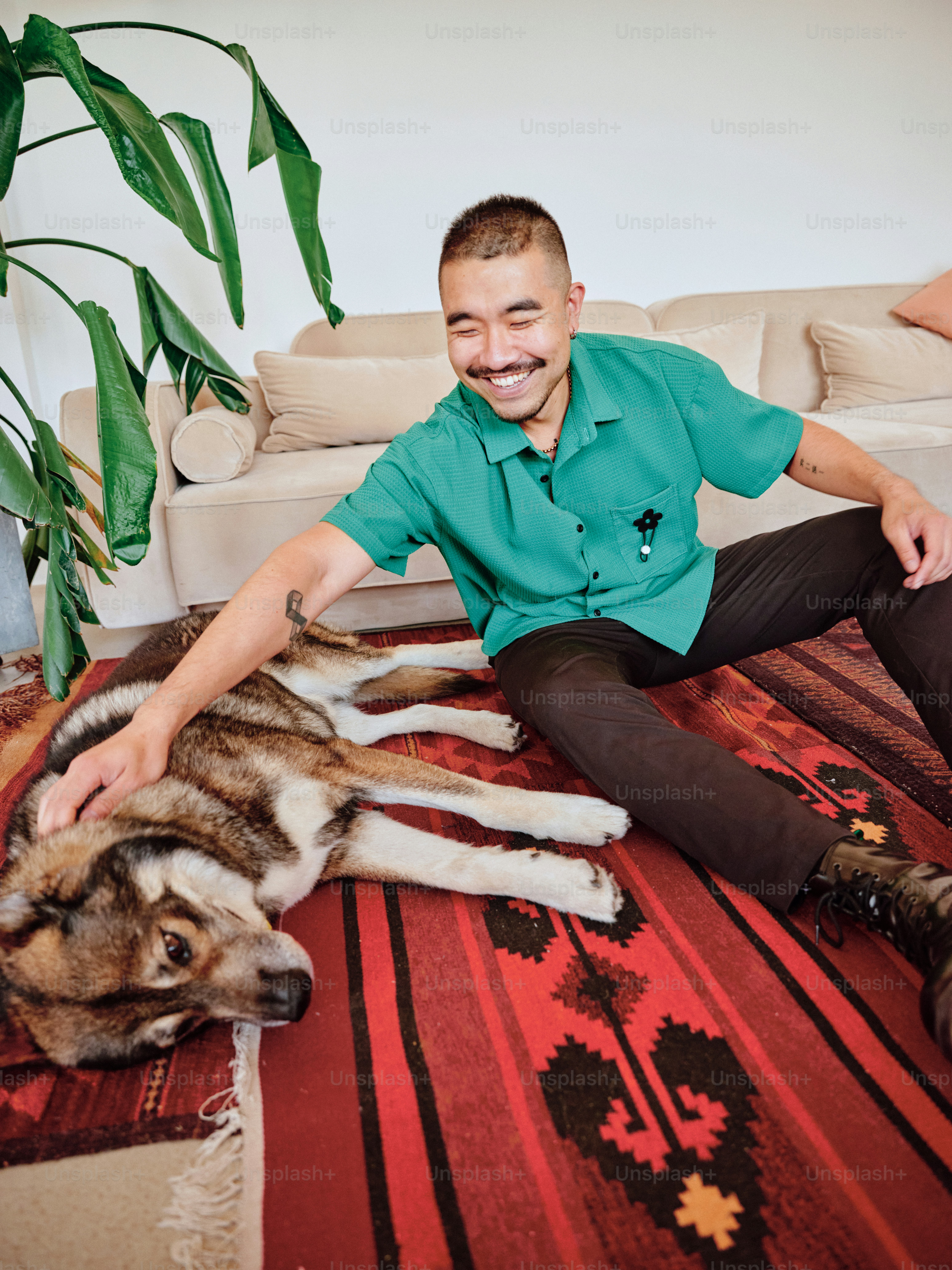 A man sitting on the floor with a dog photo – Handsome man Image on ...
