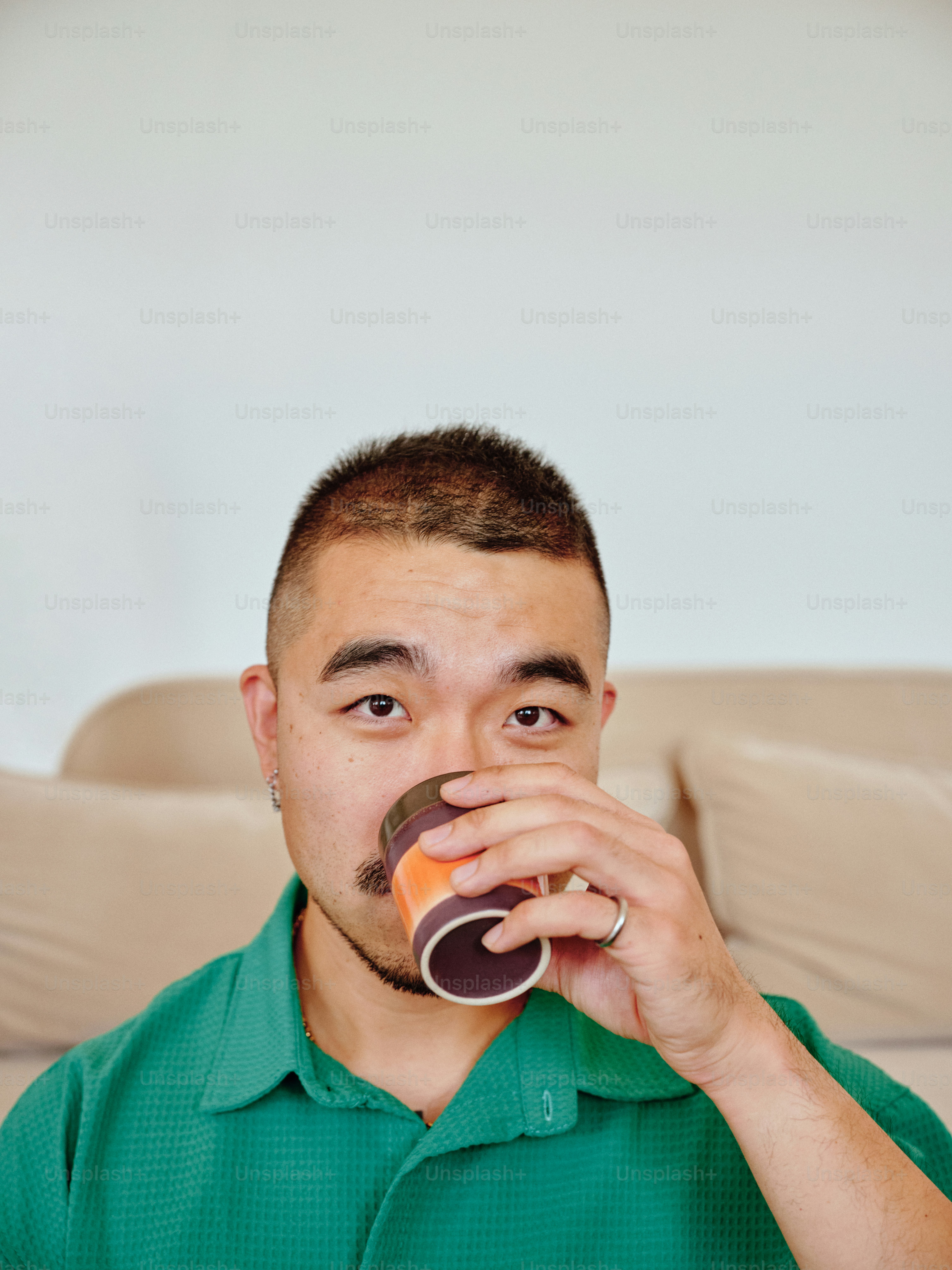 A man in a green shirt drinking a beverage