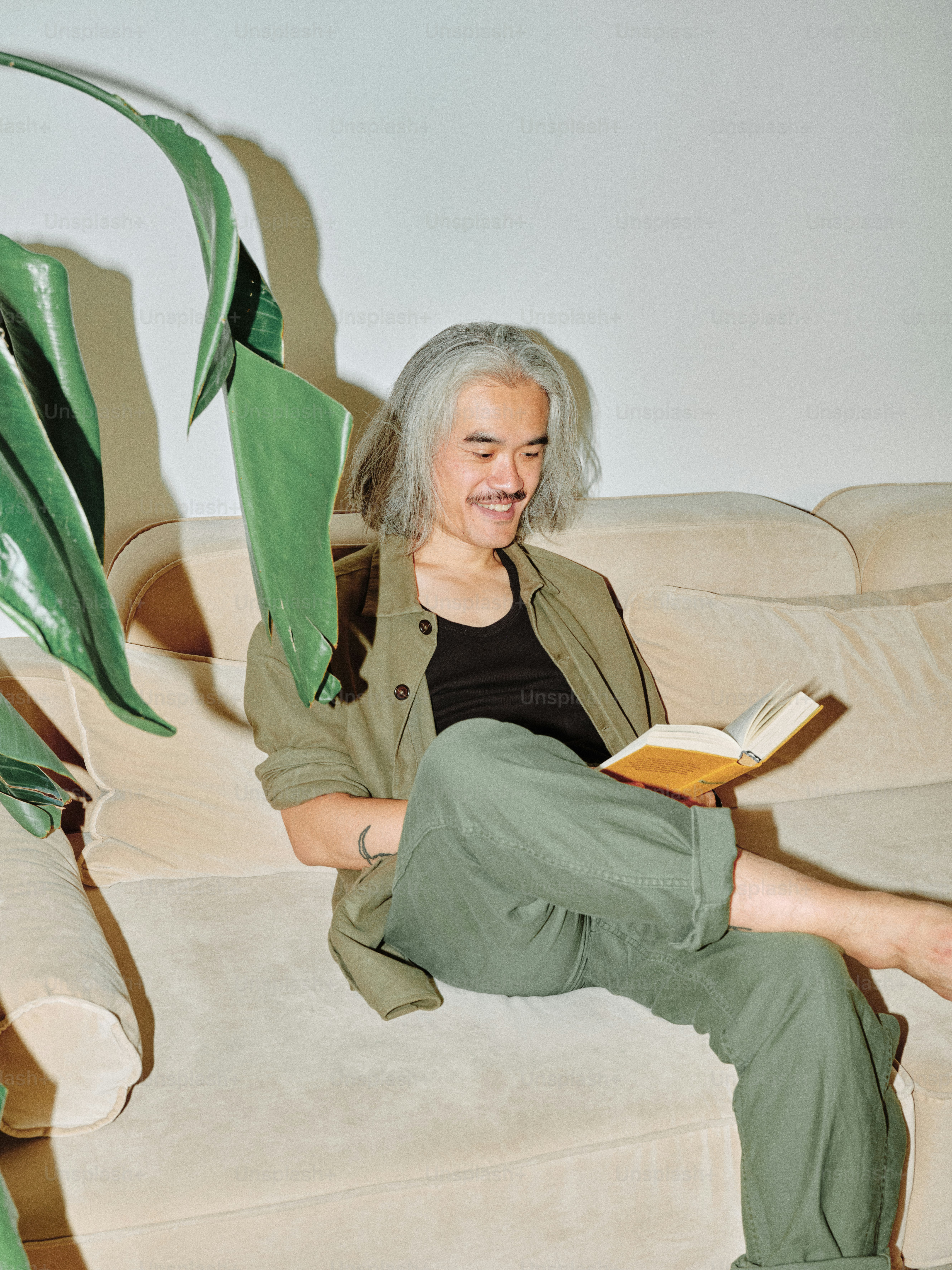 A woman sitting on a couch reading a book