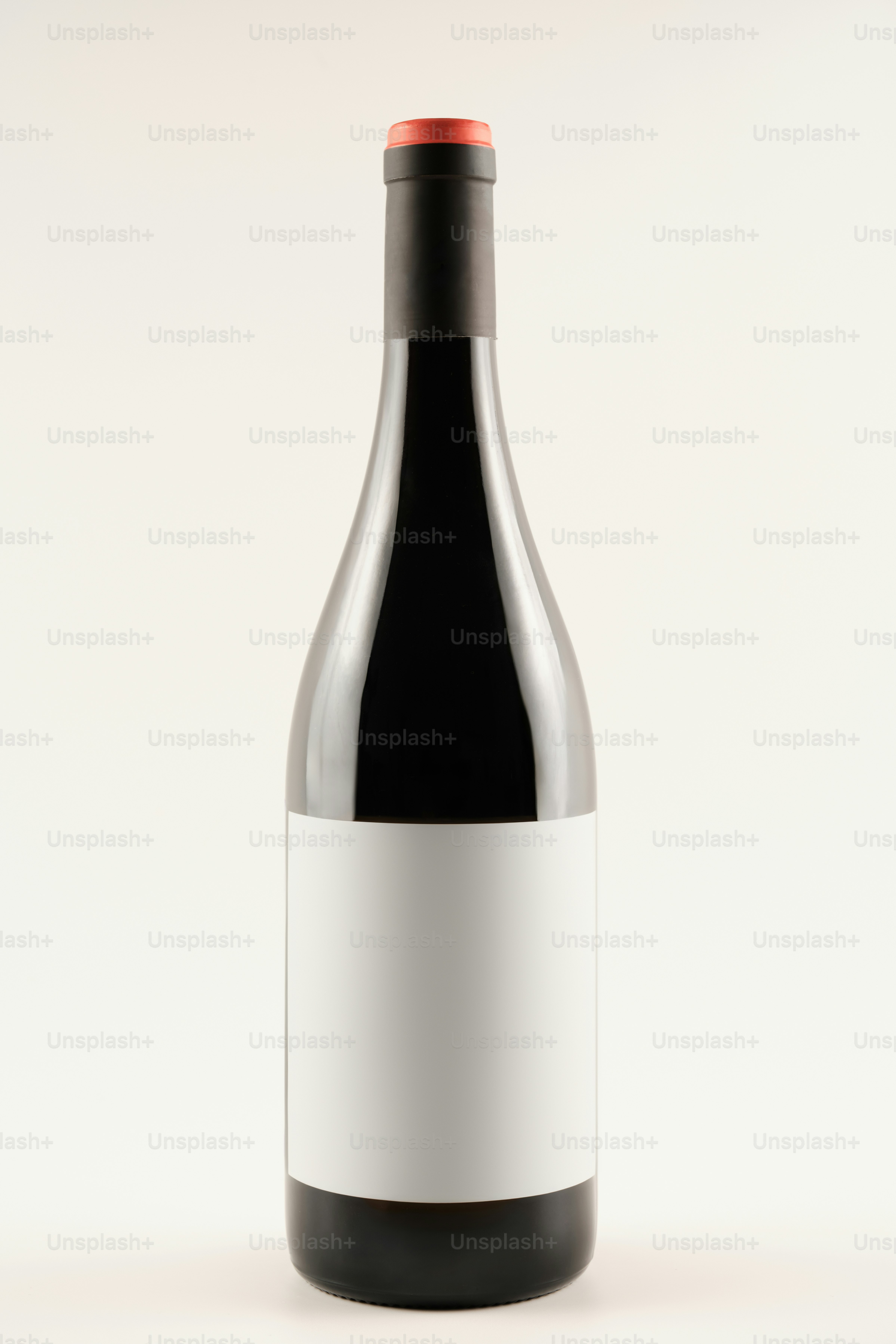 A bottle of red wine with a white label