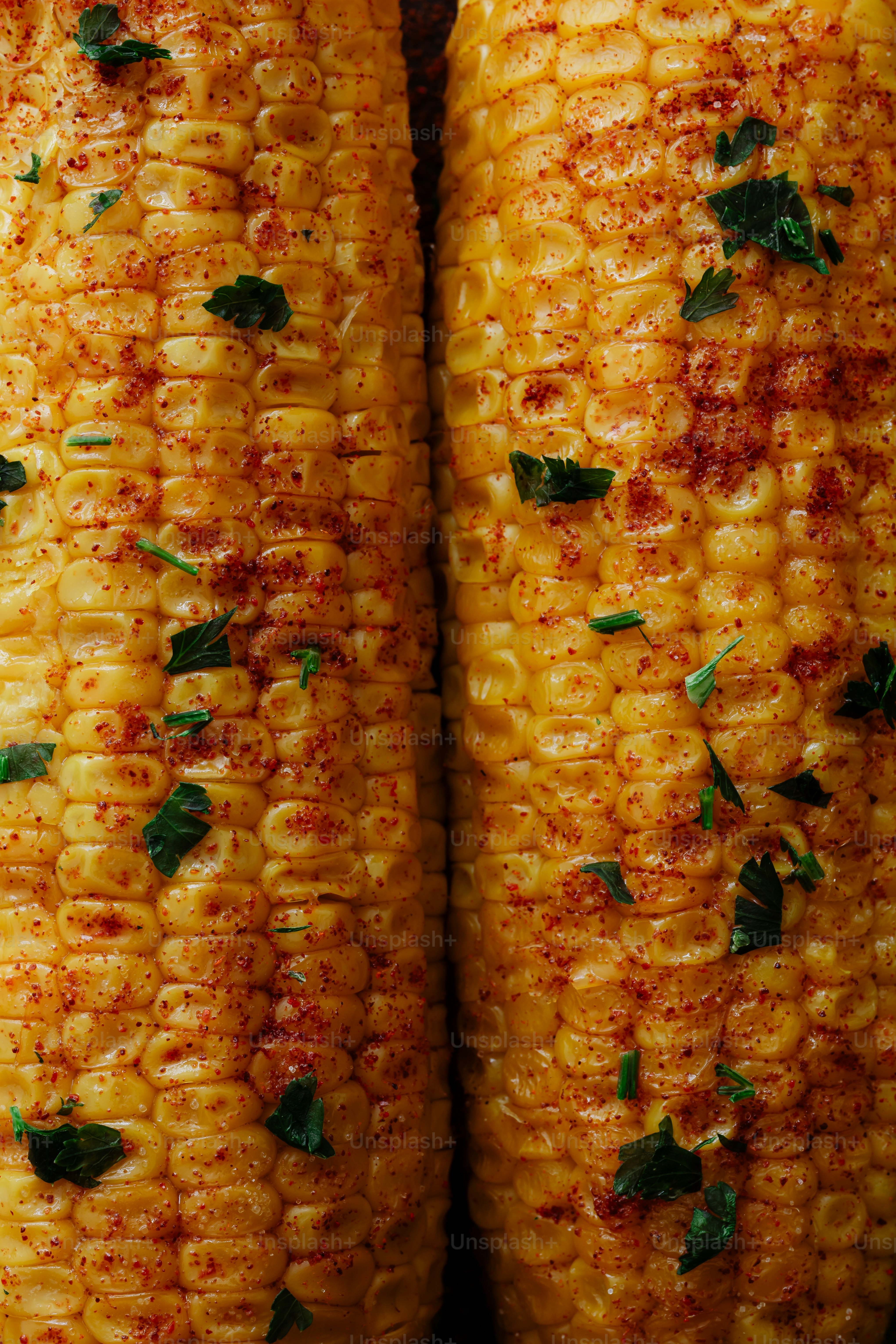 A close up of corn on the cob with herbs