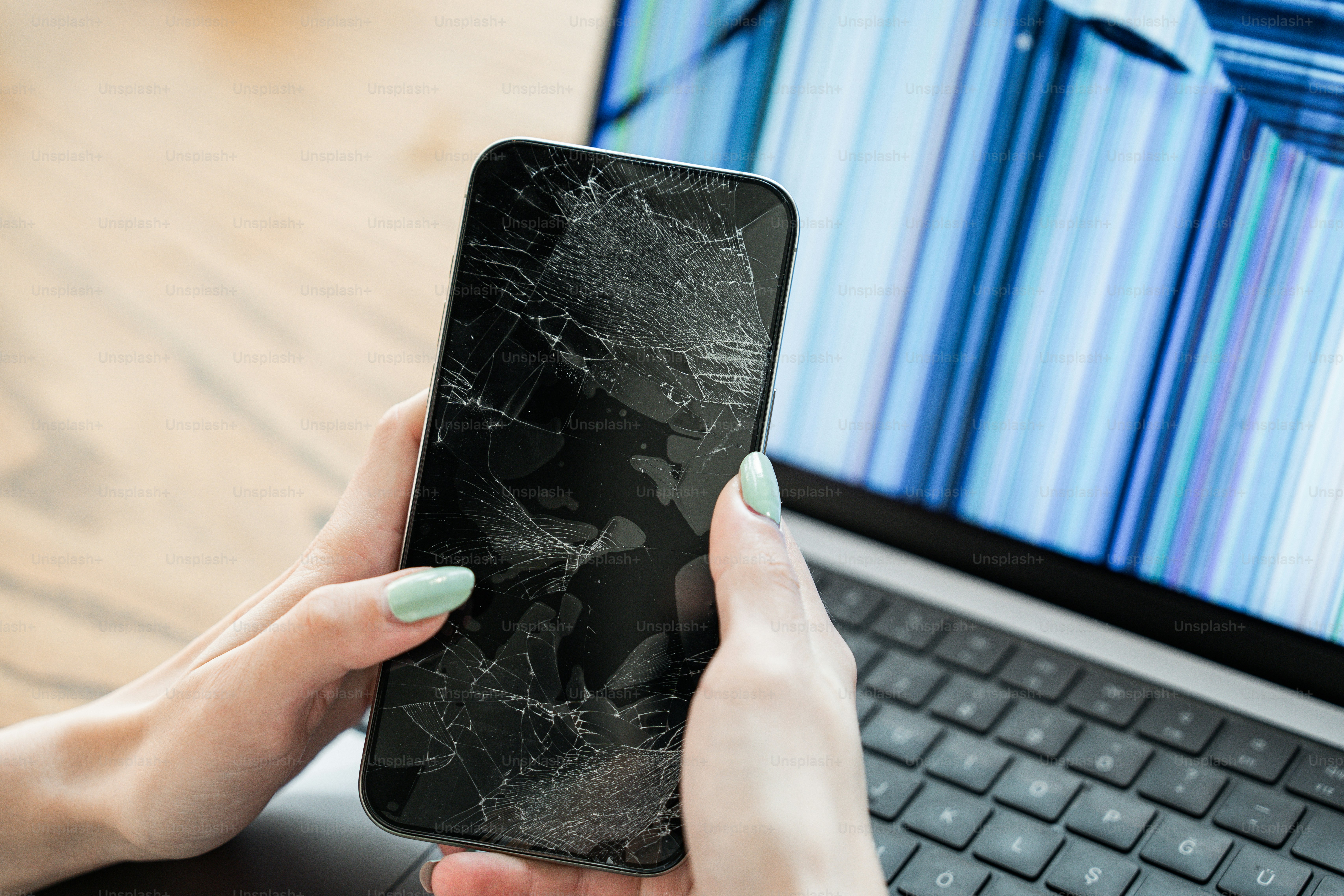Una donna che tiene un telefono cellulare davanti a un computer portatile