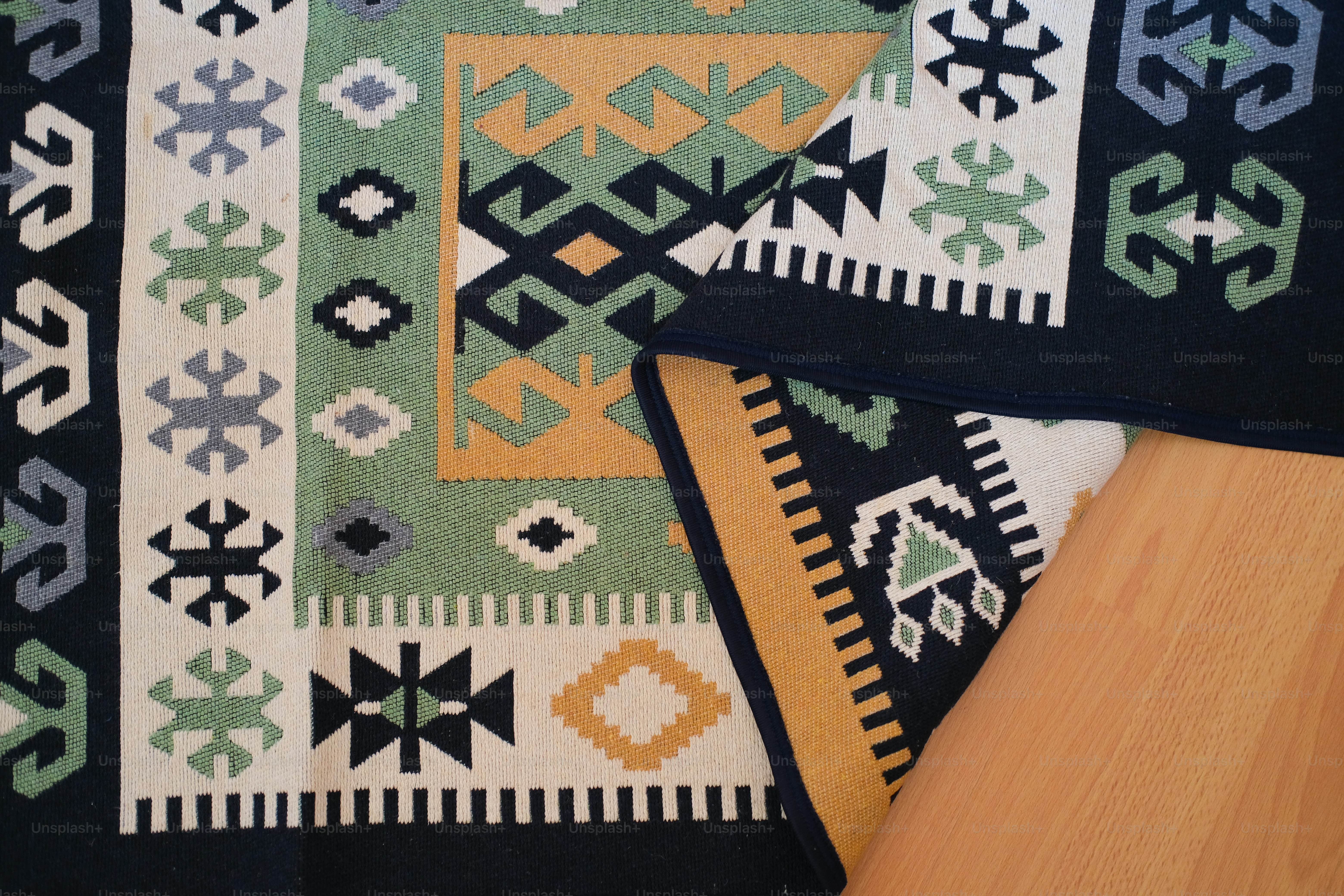 A close up of a rug on a wooden floor