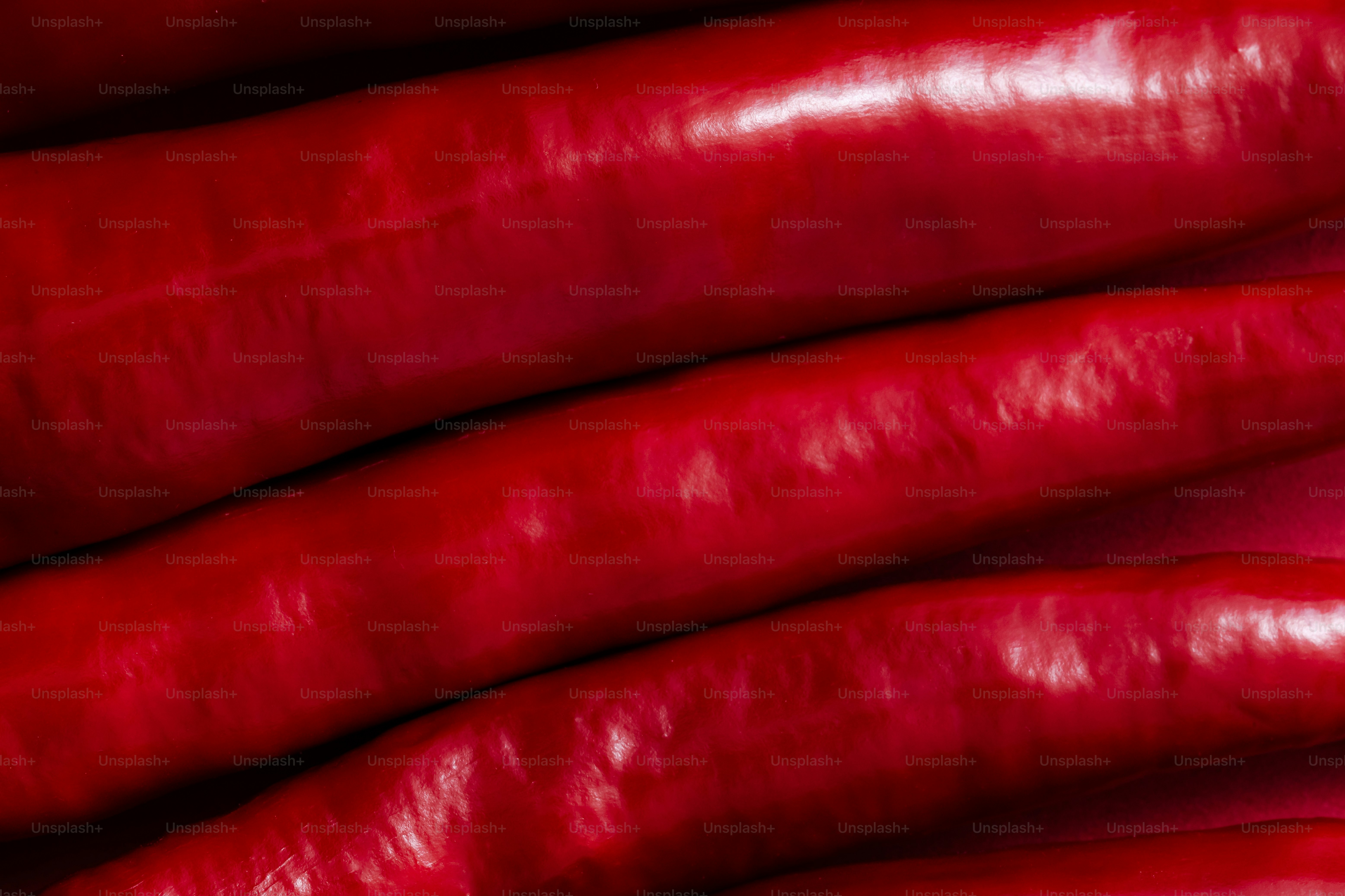 A pile of red hotdogs stacked on top of each other