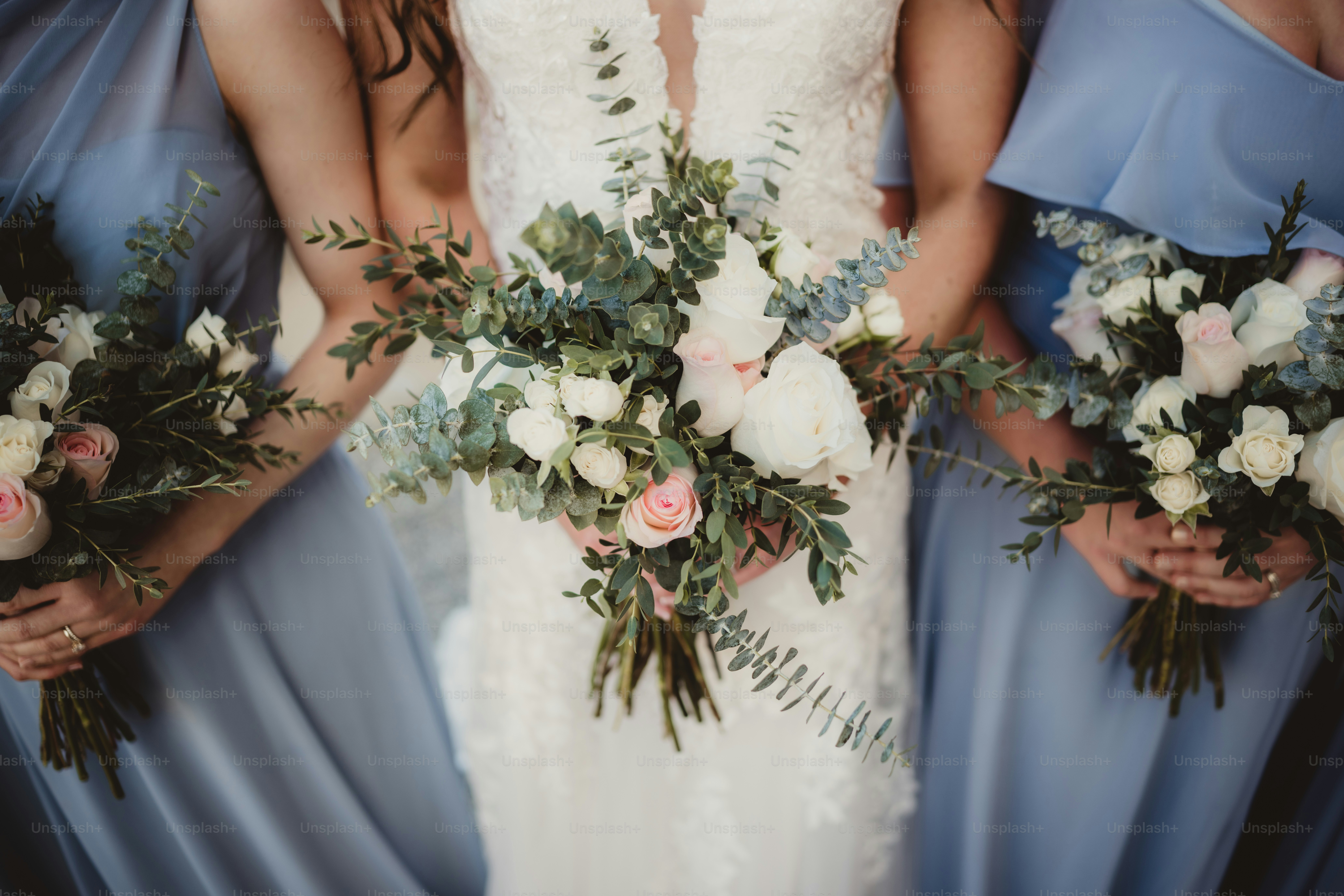 Sposa e damigelle d'onore in abiti blu con mazzi di rose bianche
