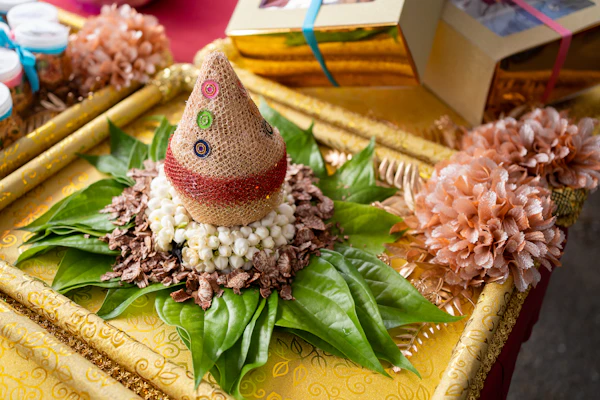 Decorative ceremonial coconut with betel leaves and jasmine flower on a gold thamboolam plate