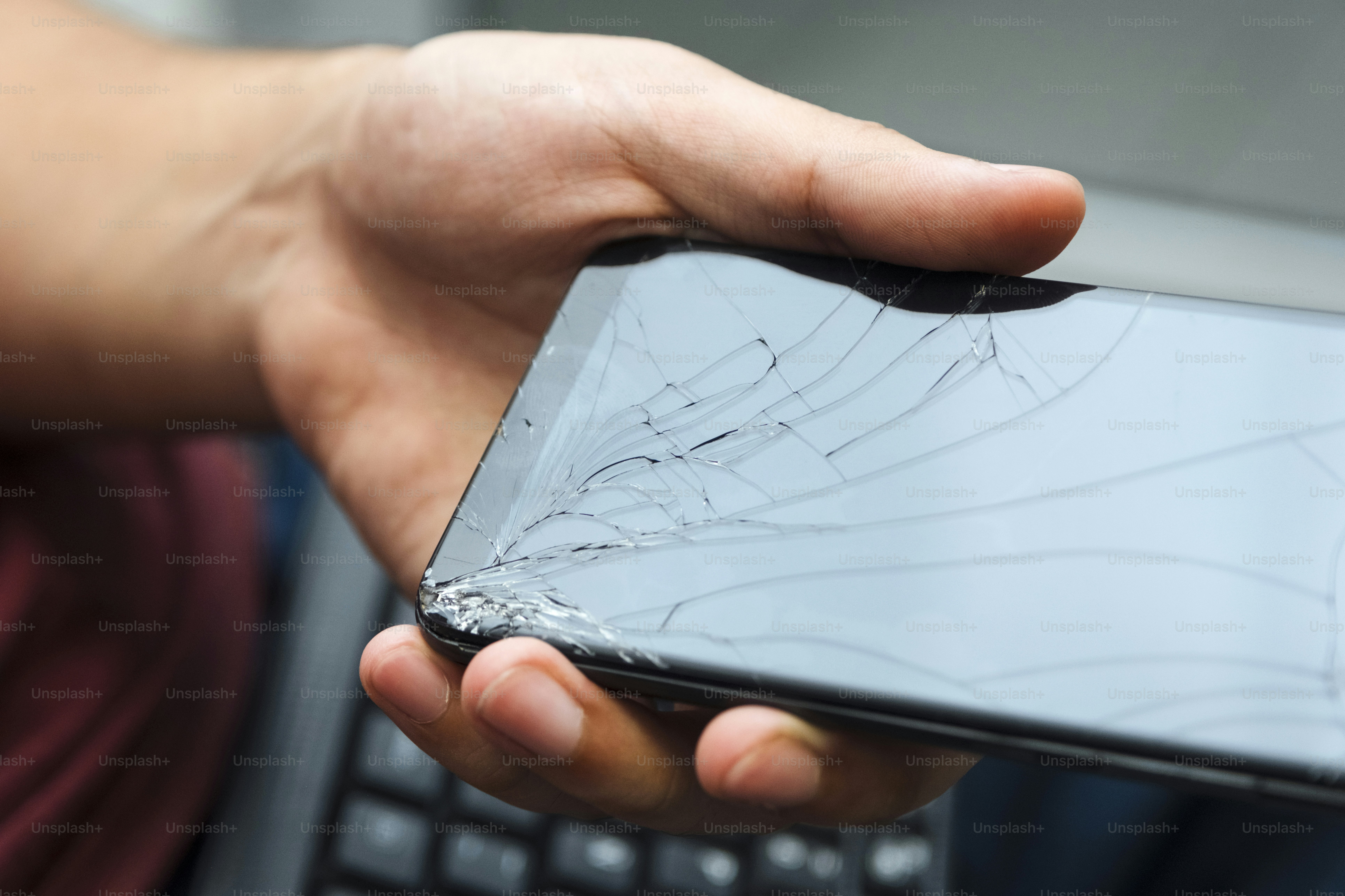 A person holding a broken cell phone in their hand