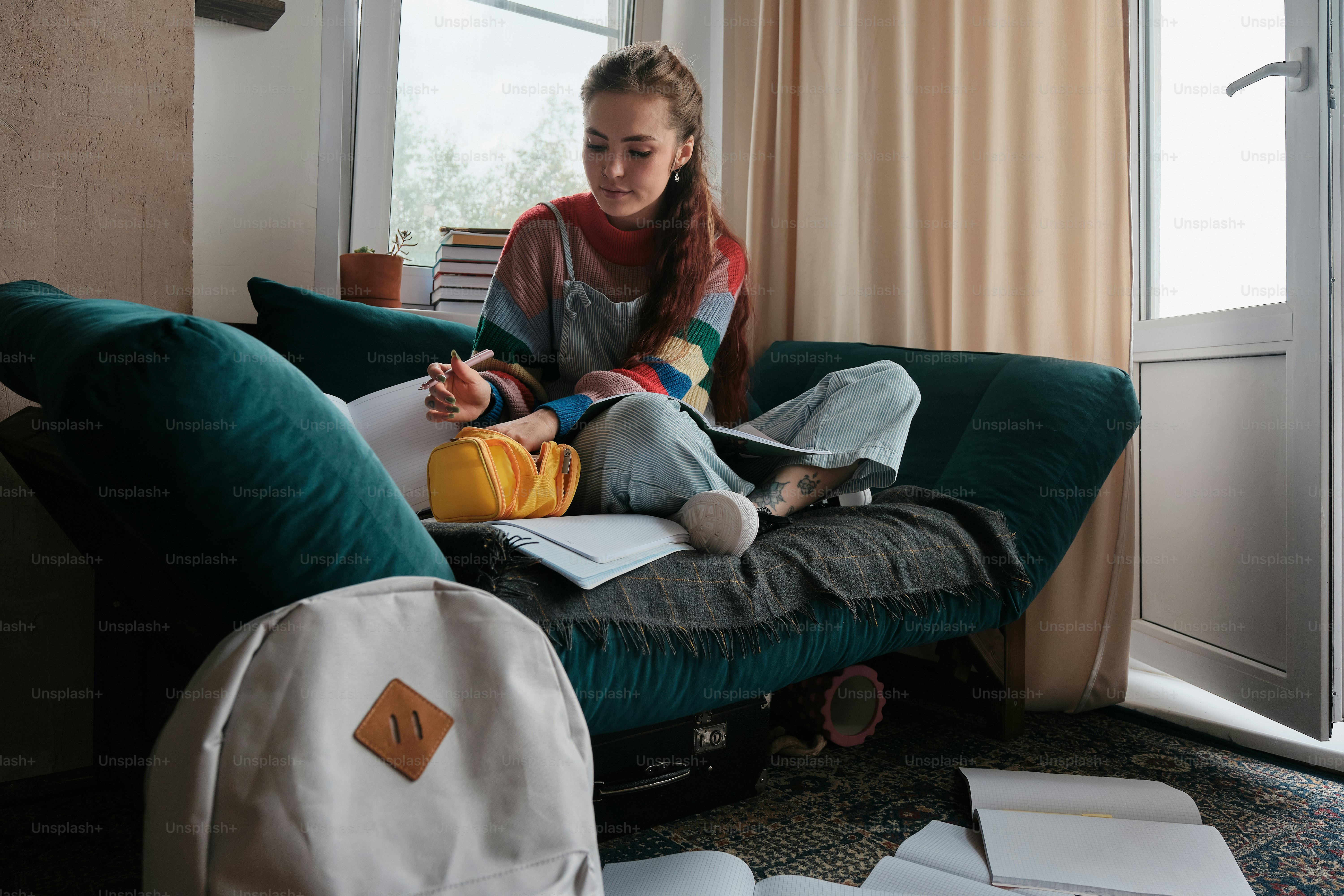 A woman sitting on a couch with a backpack