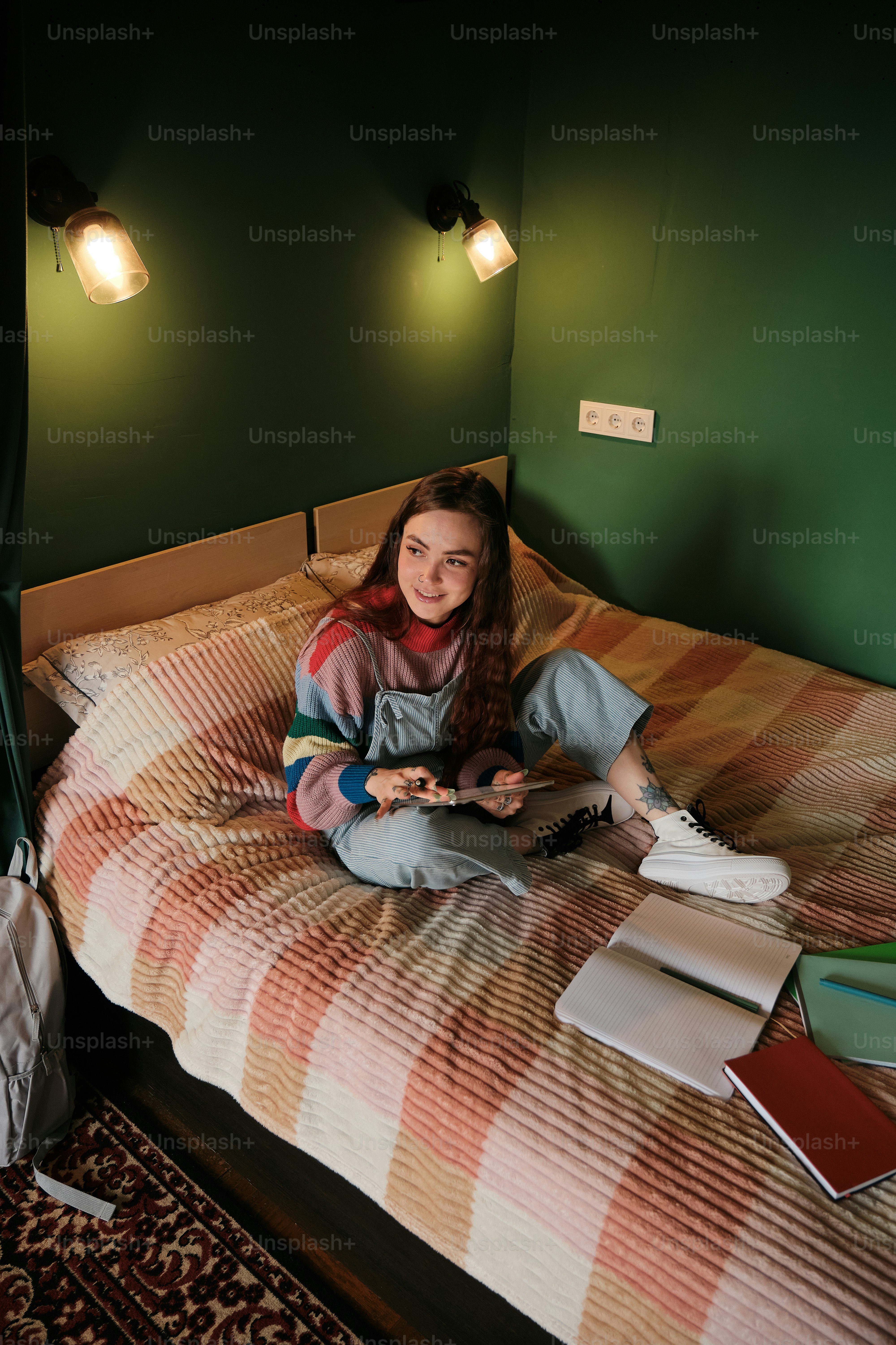 A woman sitting on a bed in a green room