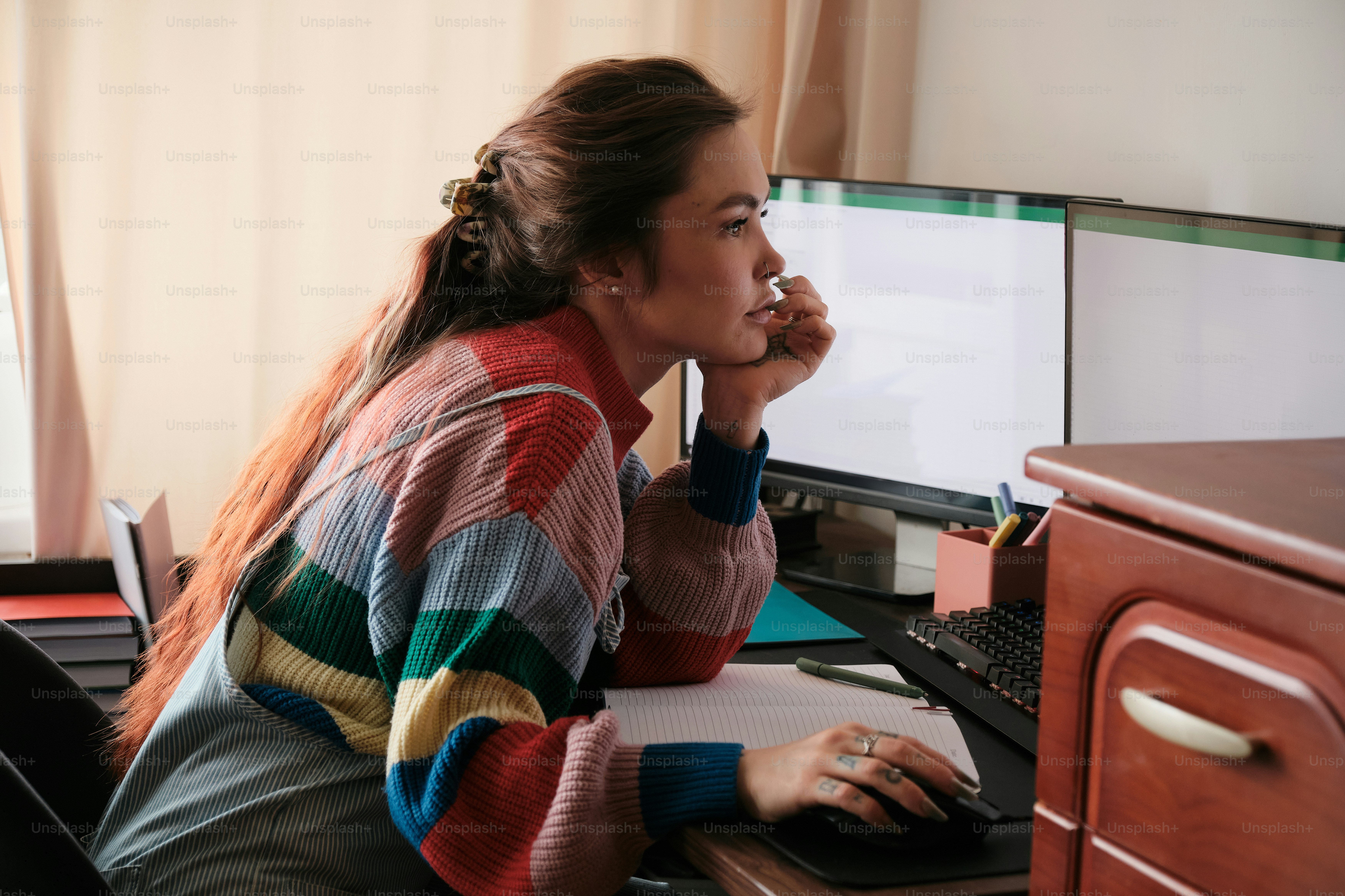A woman sitting at a desk using a computer photo – Girl Image on Unsplash