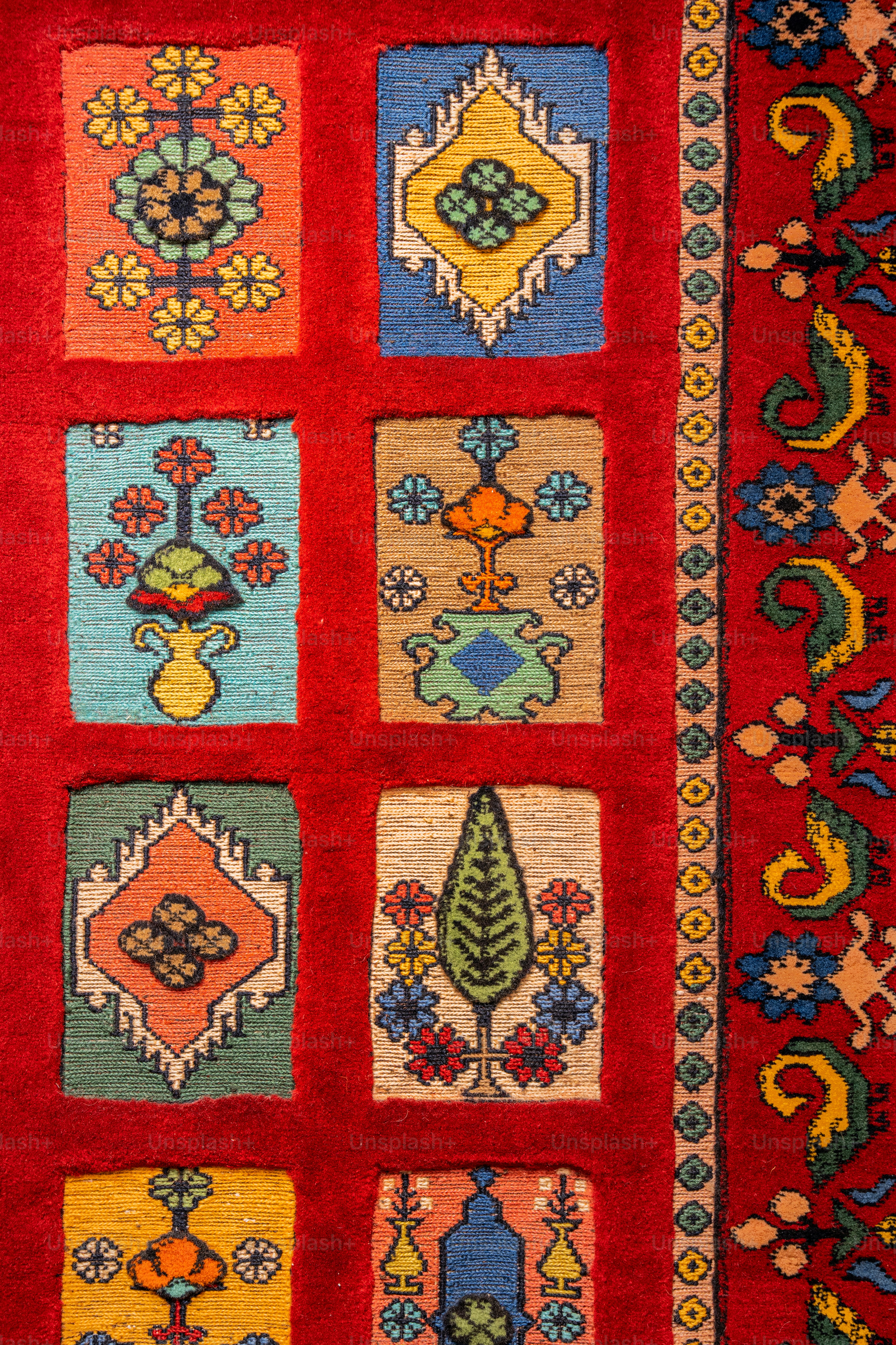 A red rug with a bunch of different designs on it