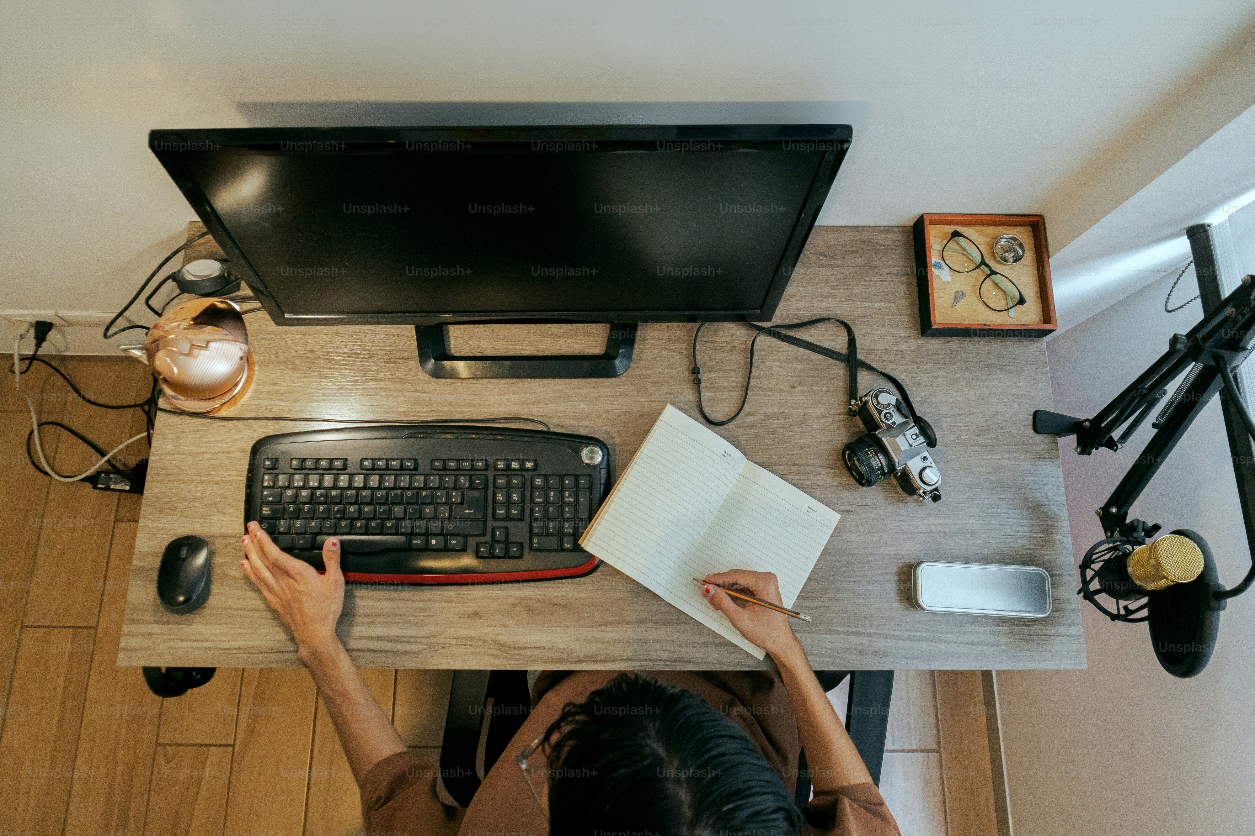 A person sitting at a desk with a computer and a book photo – Student ...