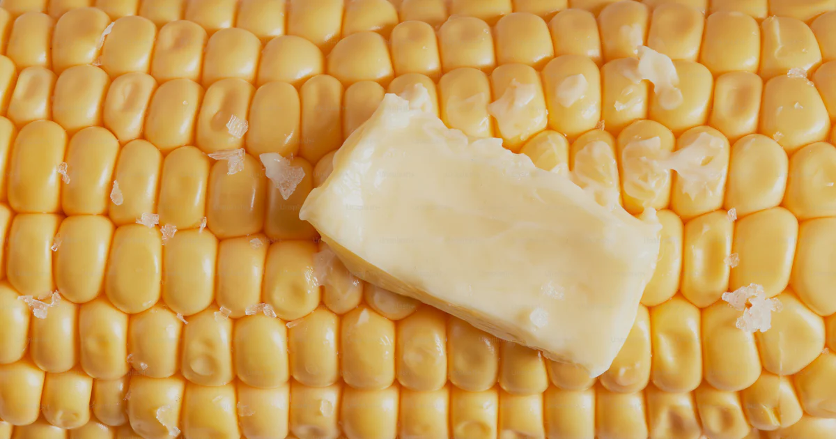 Kernel Butter A piece of butter sits on top of a corn cob photo – Corn kernels Image ...