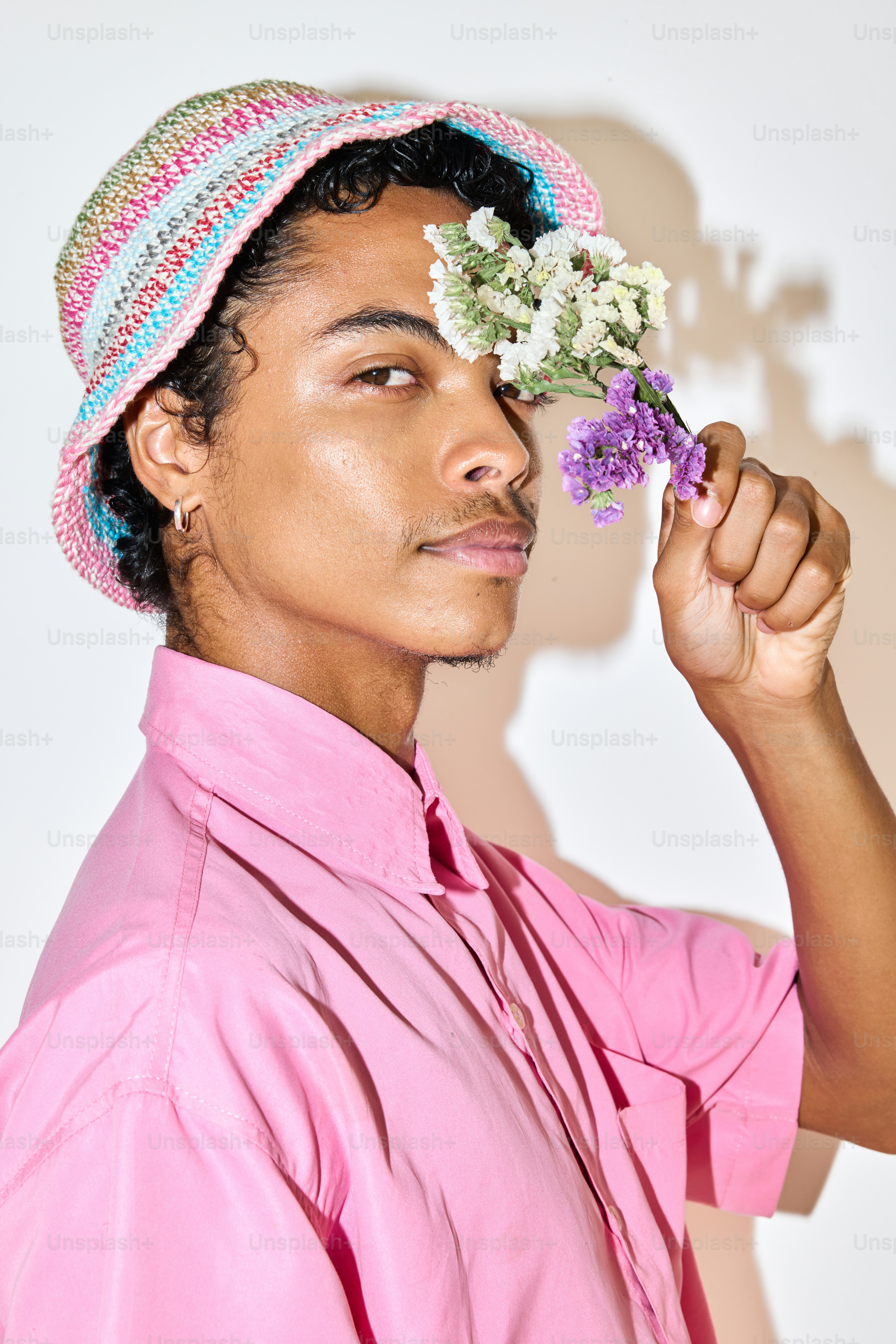 분홍색 셔츠를 입고 머리에 꽃을 꽂은 남자