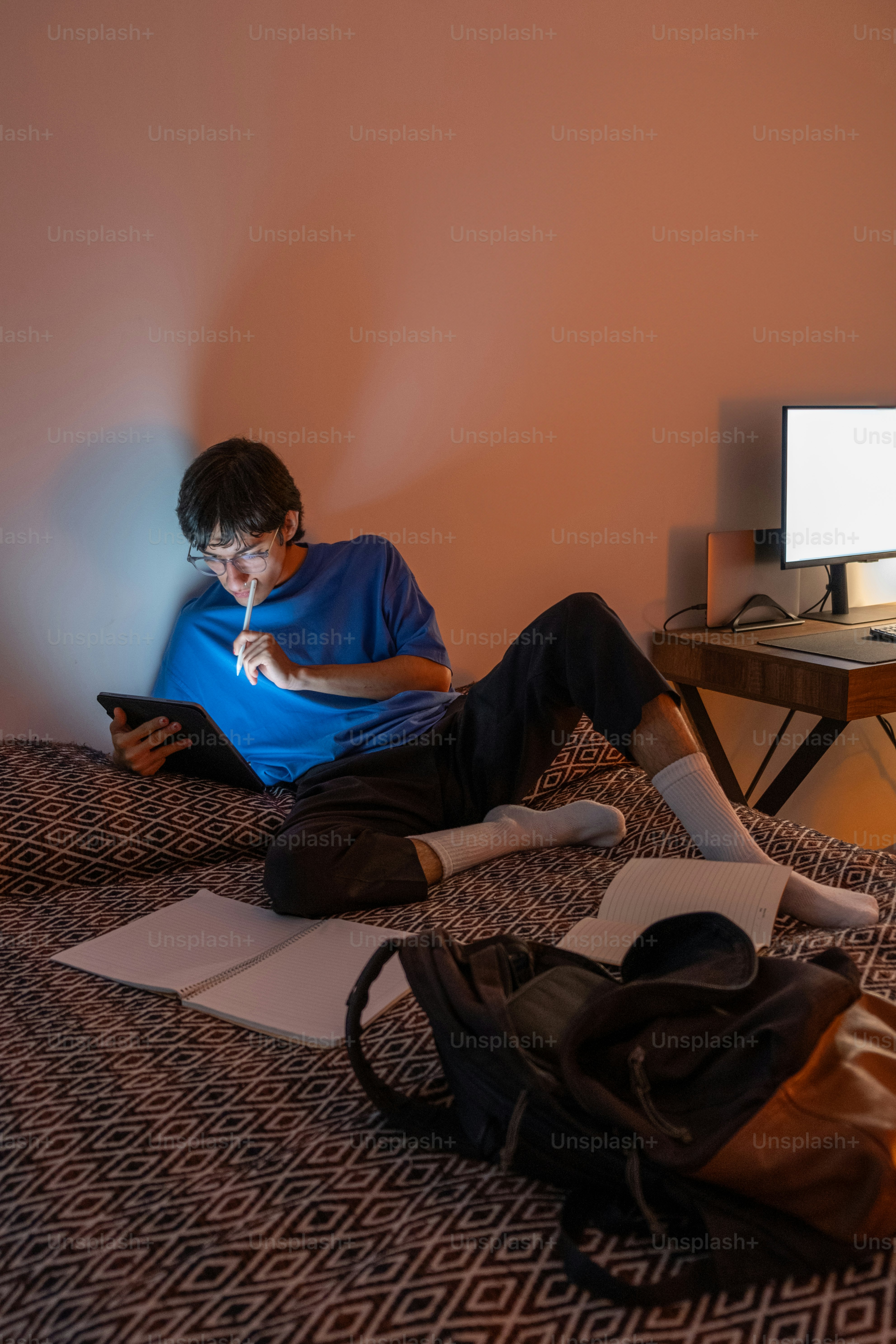 A man sitting on a bed using a laptop computer