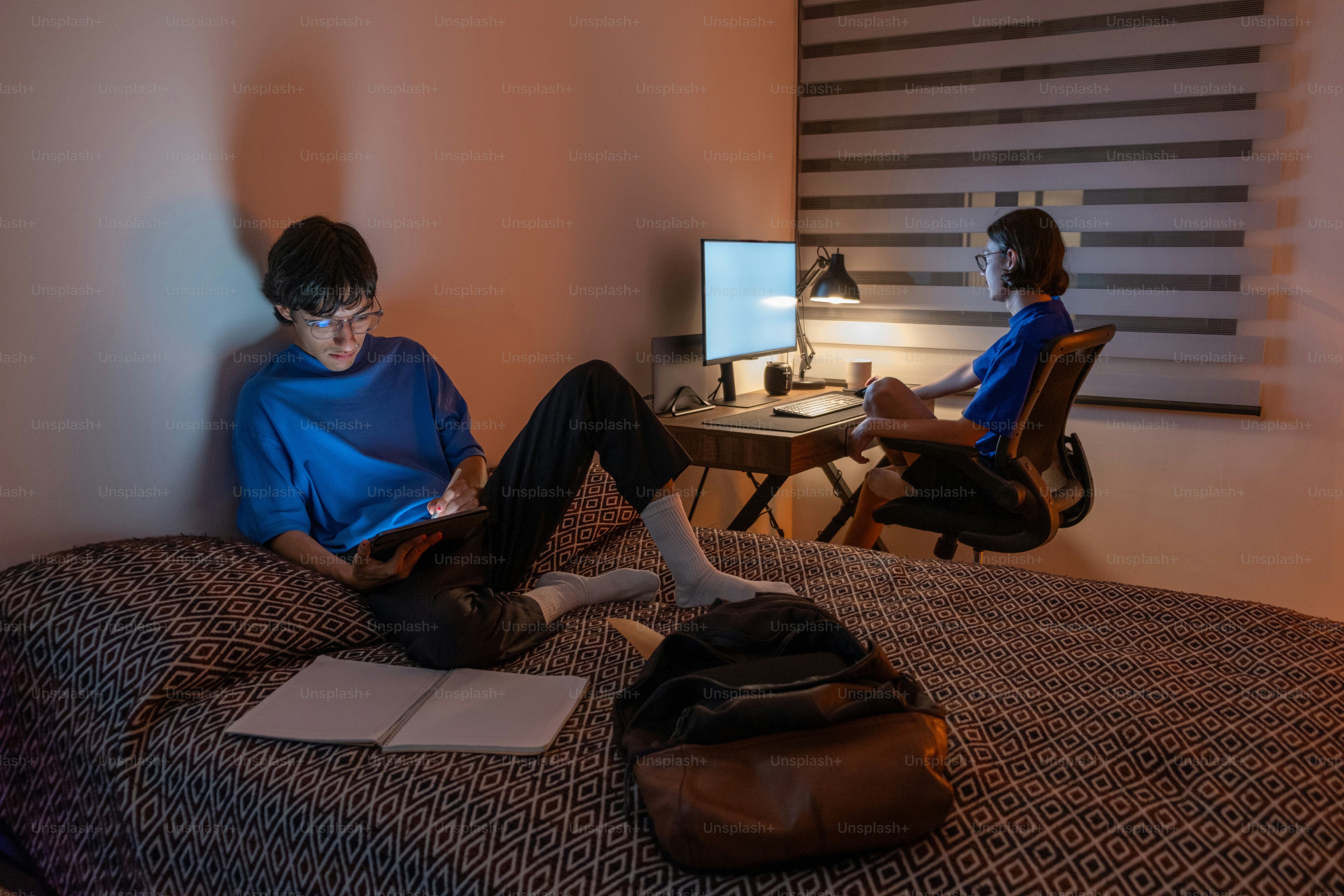 Two people sitting on a bed in a room