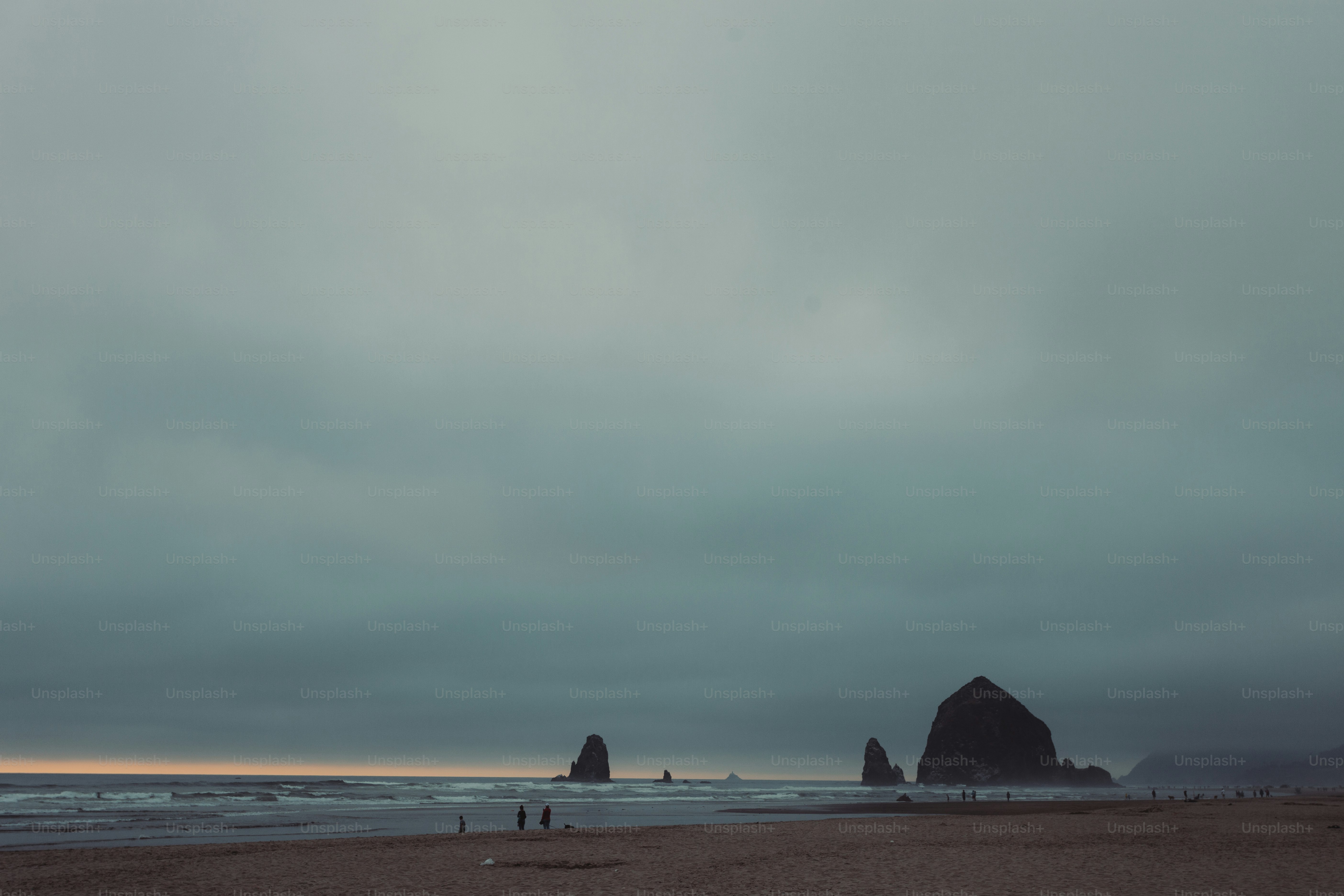 A group of people standing on top of a sandy beach