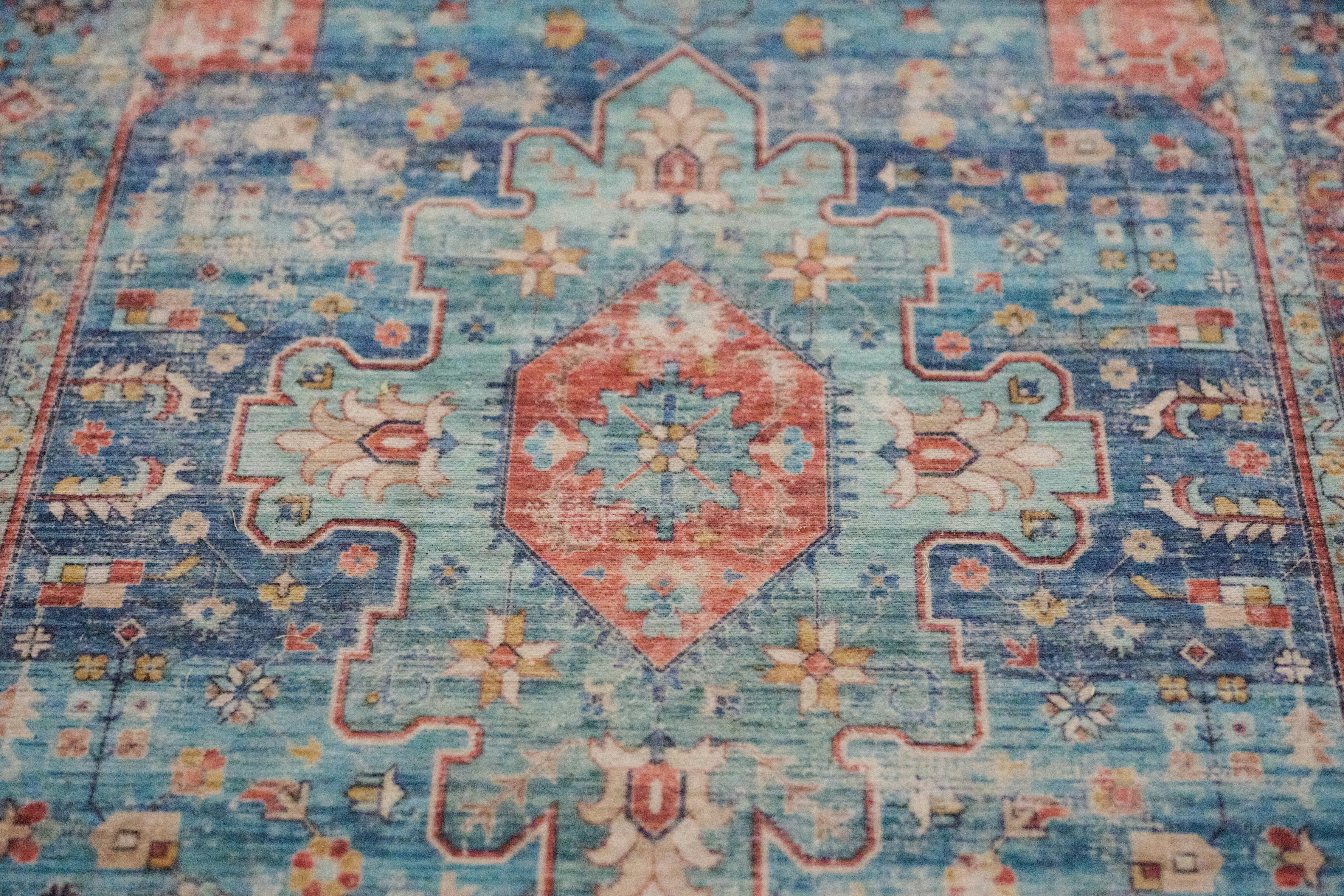 A blue and red rug with an intricate design