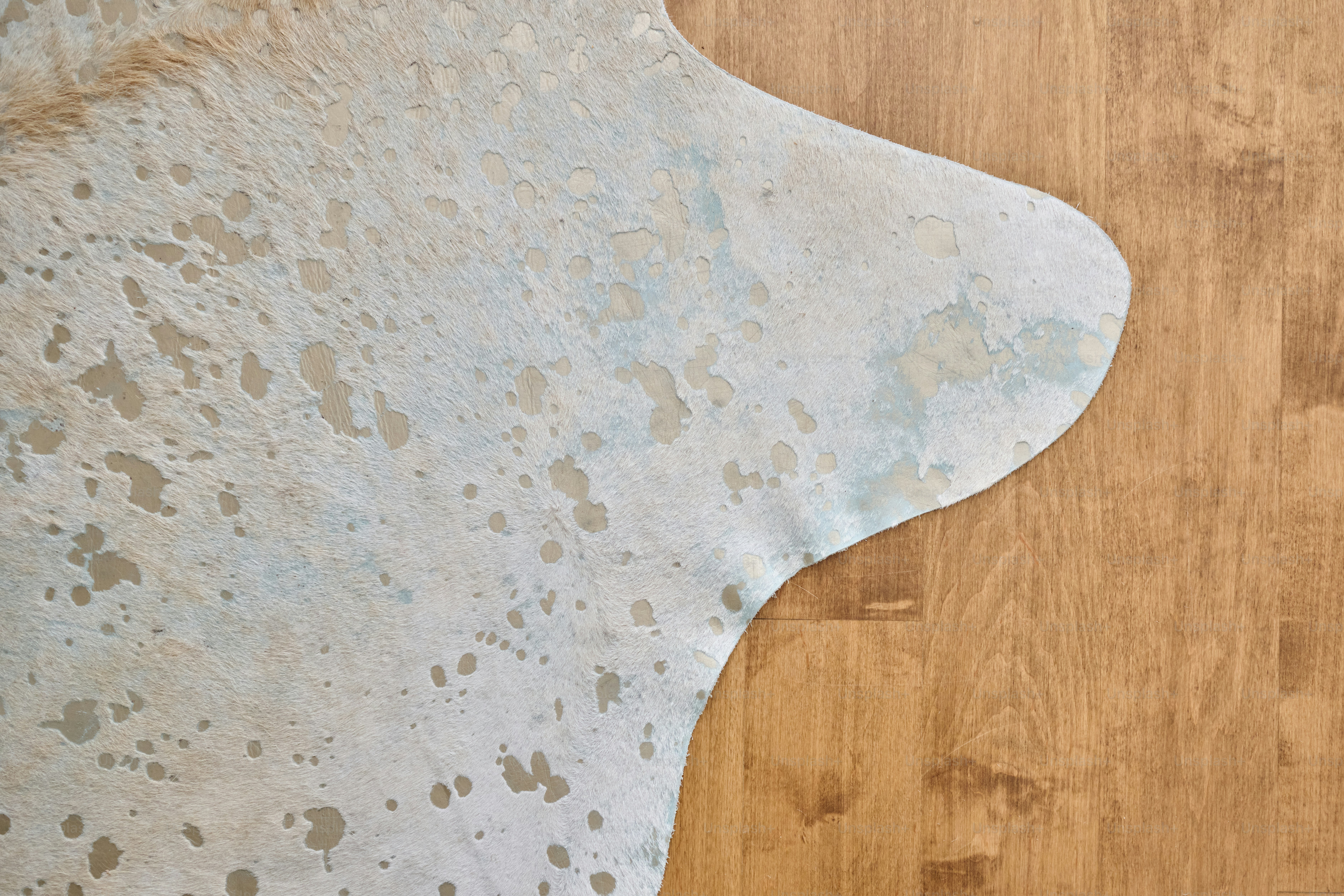 A wooden floor with a white rug on top of it
