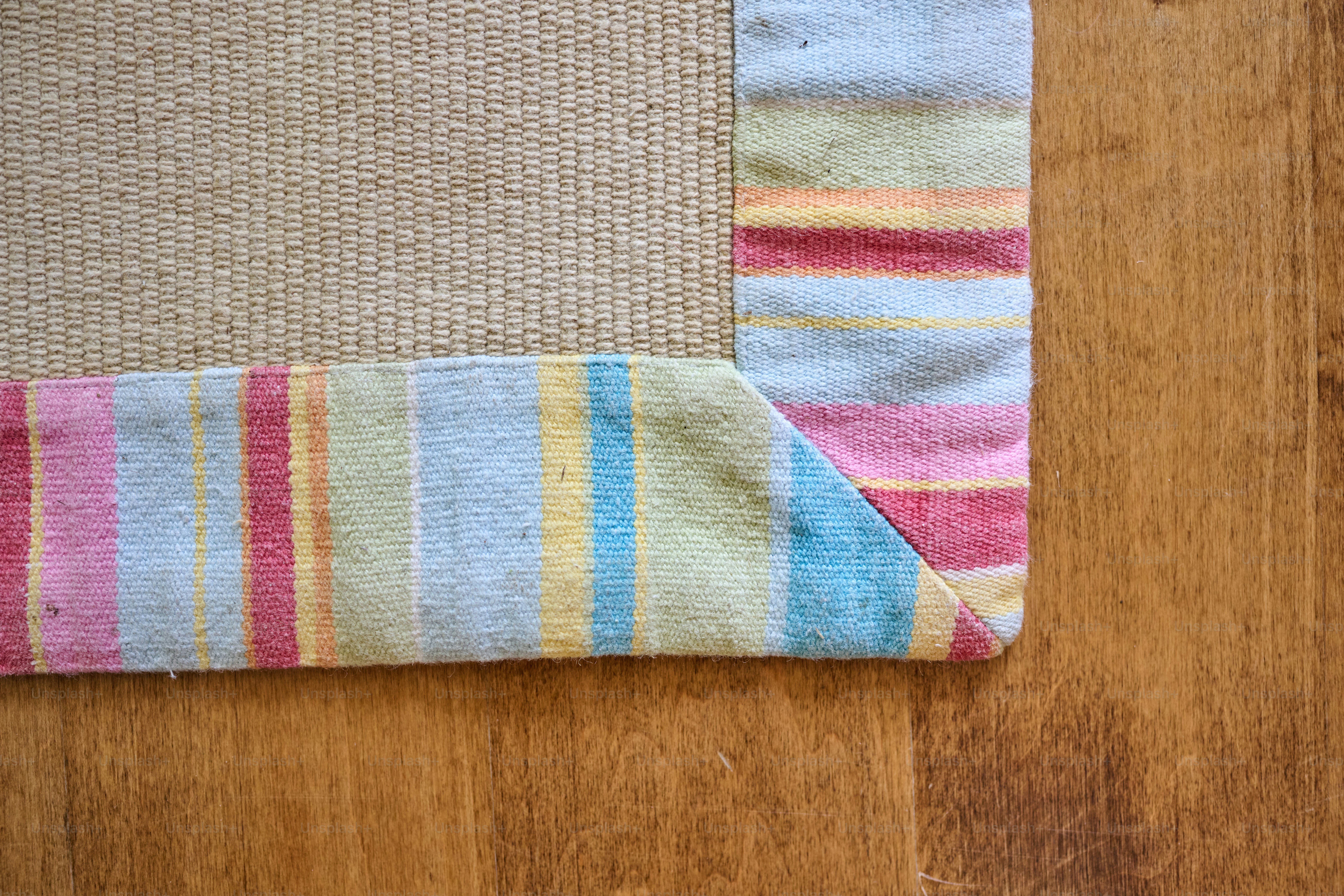 A close up of a rug on a wooden floor