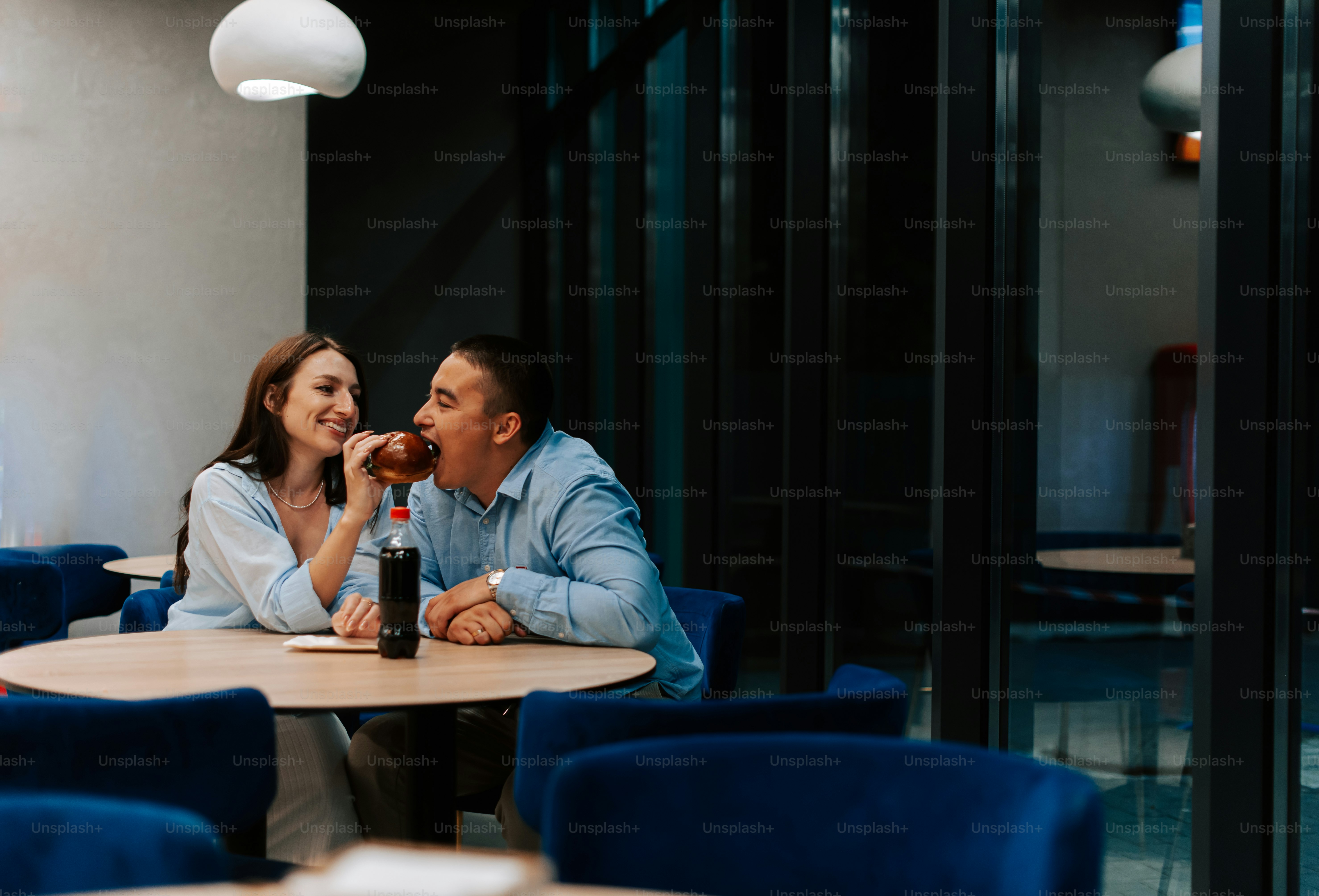A man and woman sitting at a table in a restaurant photo – Couple Image ...