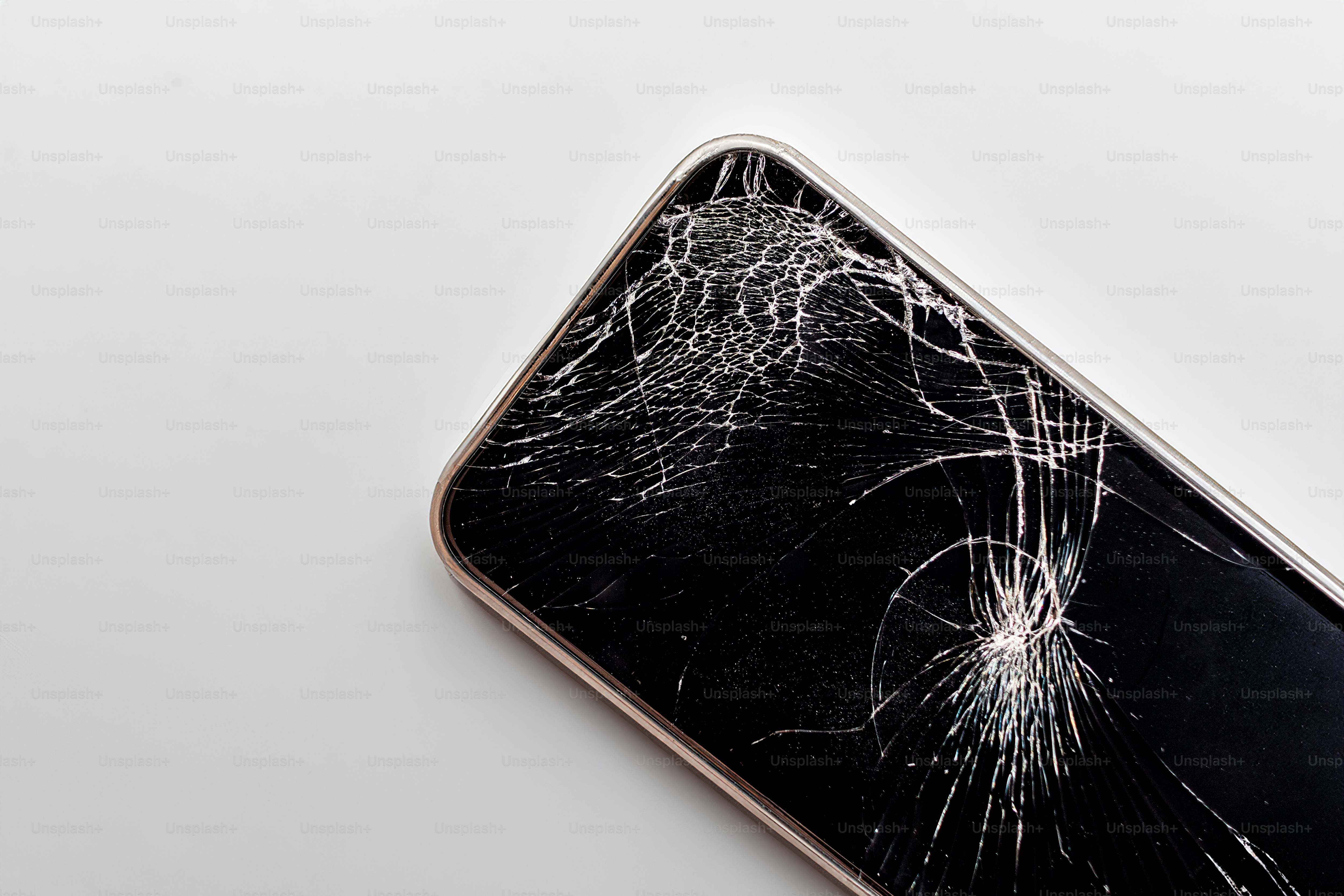 A broken cell phone with a cracked screen