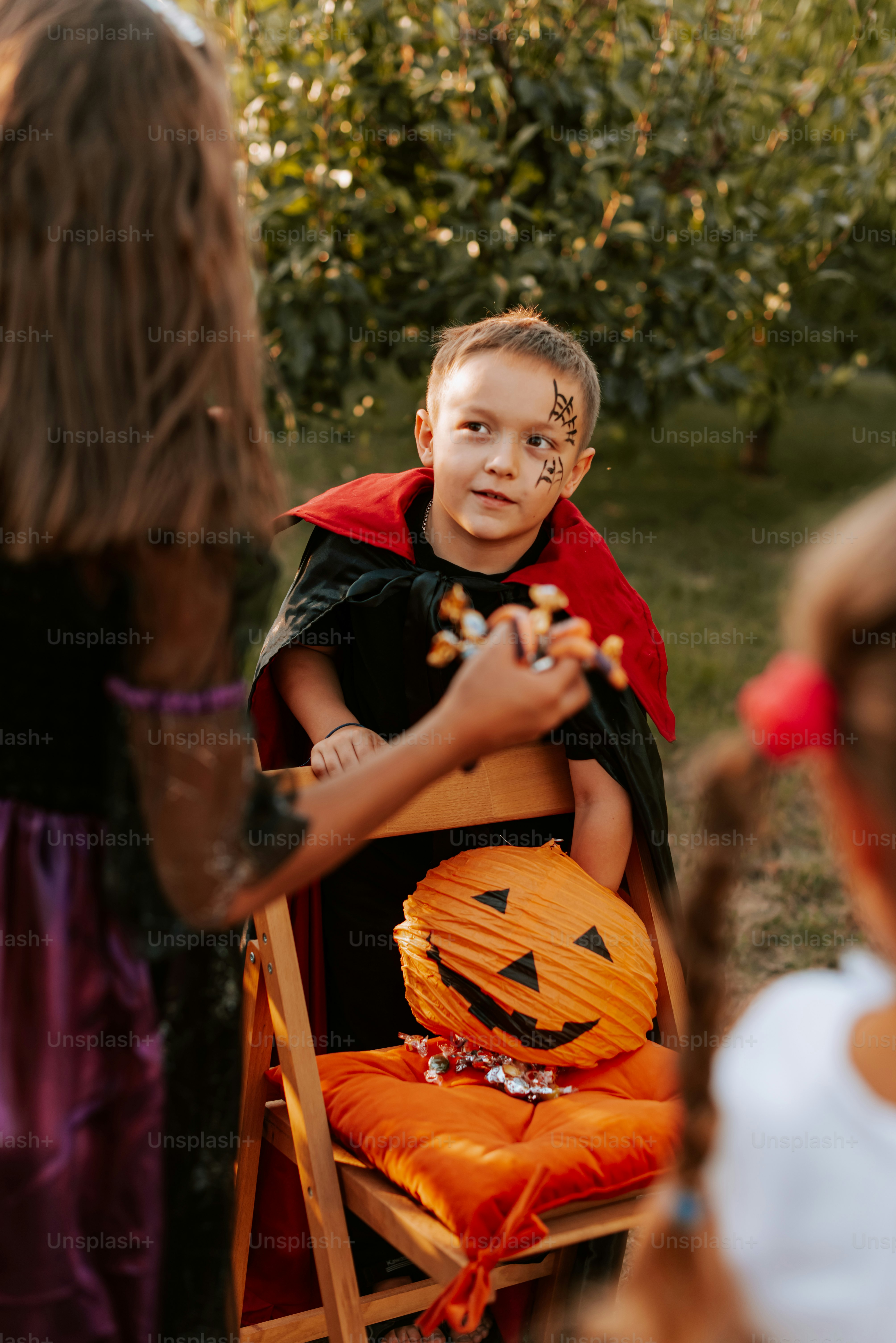 A little boy dressed up as a jack - o - lantern