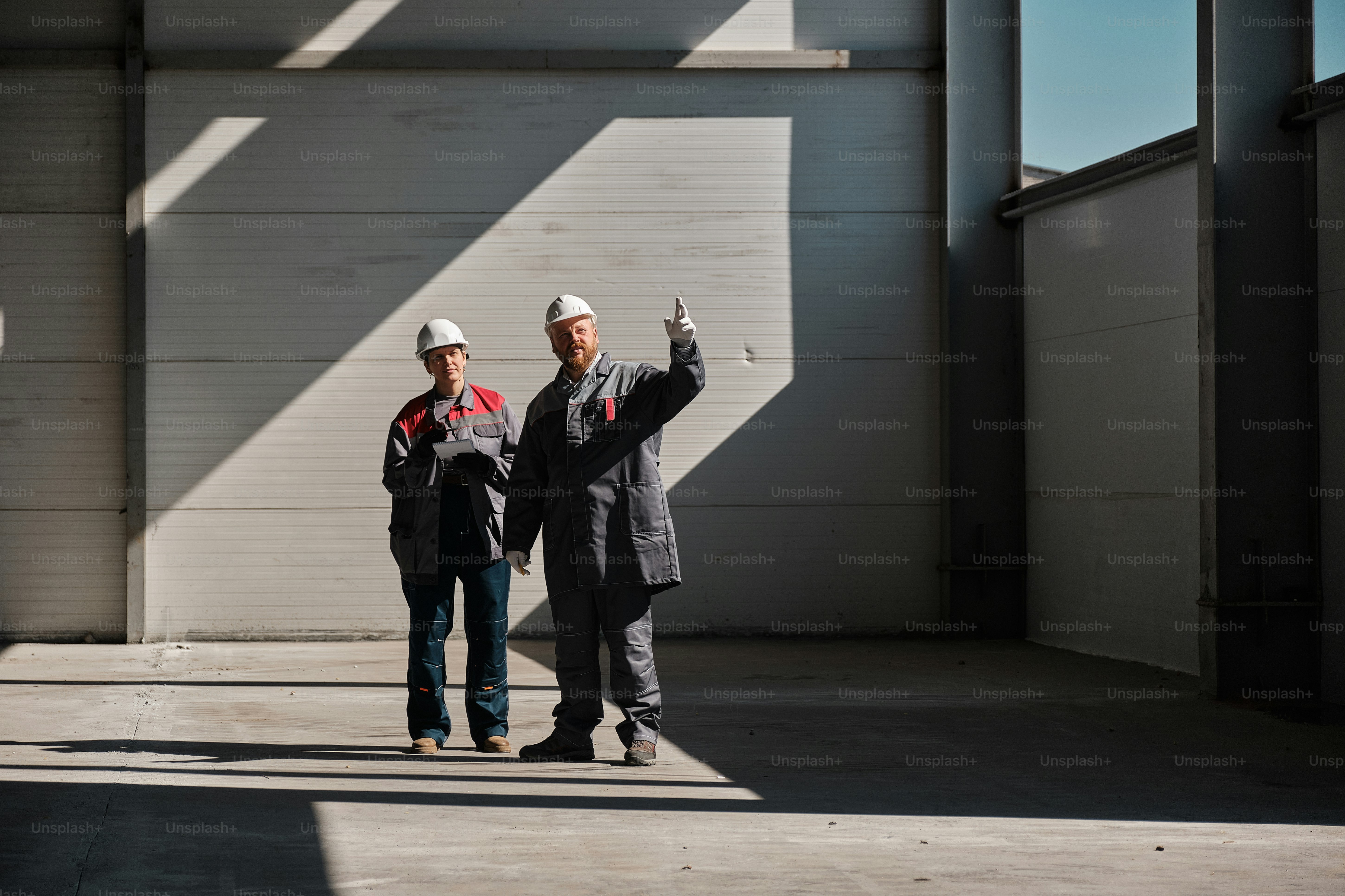 A couple of men standing next to a machine photo – Team Image on Unsplash