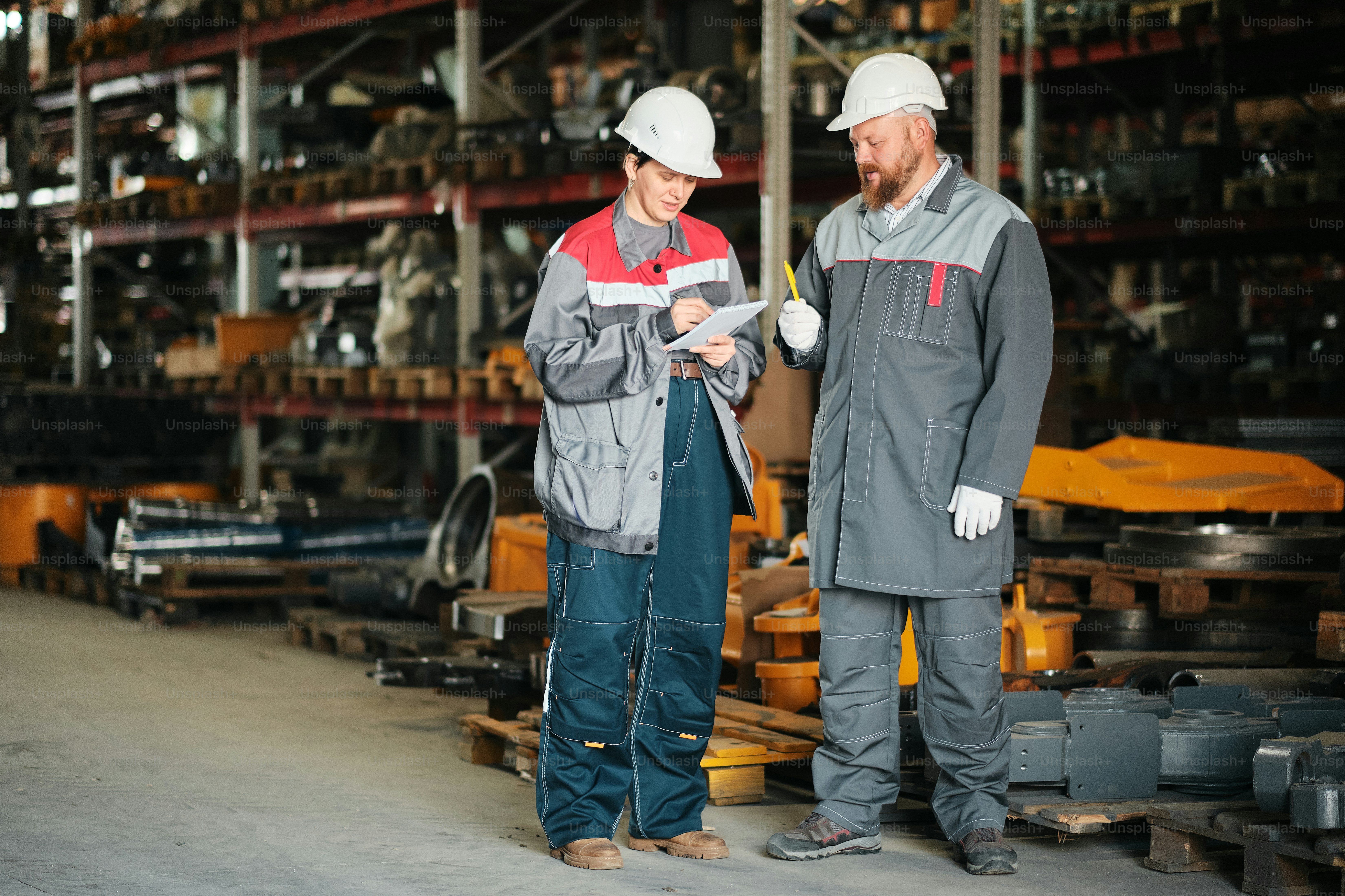 A couple of men standing next to each other in a warehouse