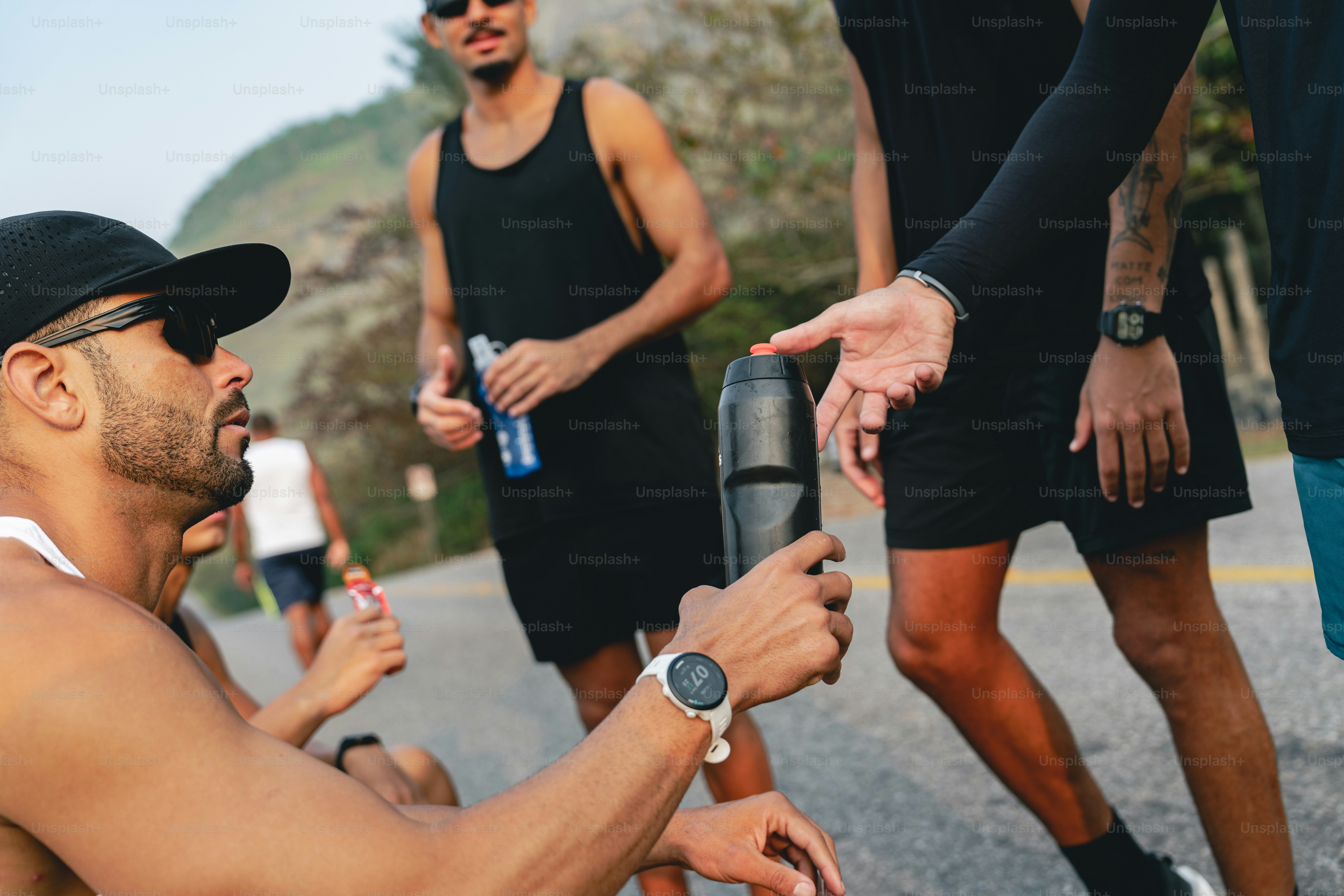 A group of people standing around a man holding a water bottle