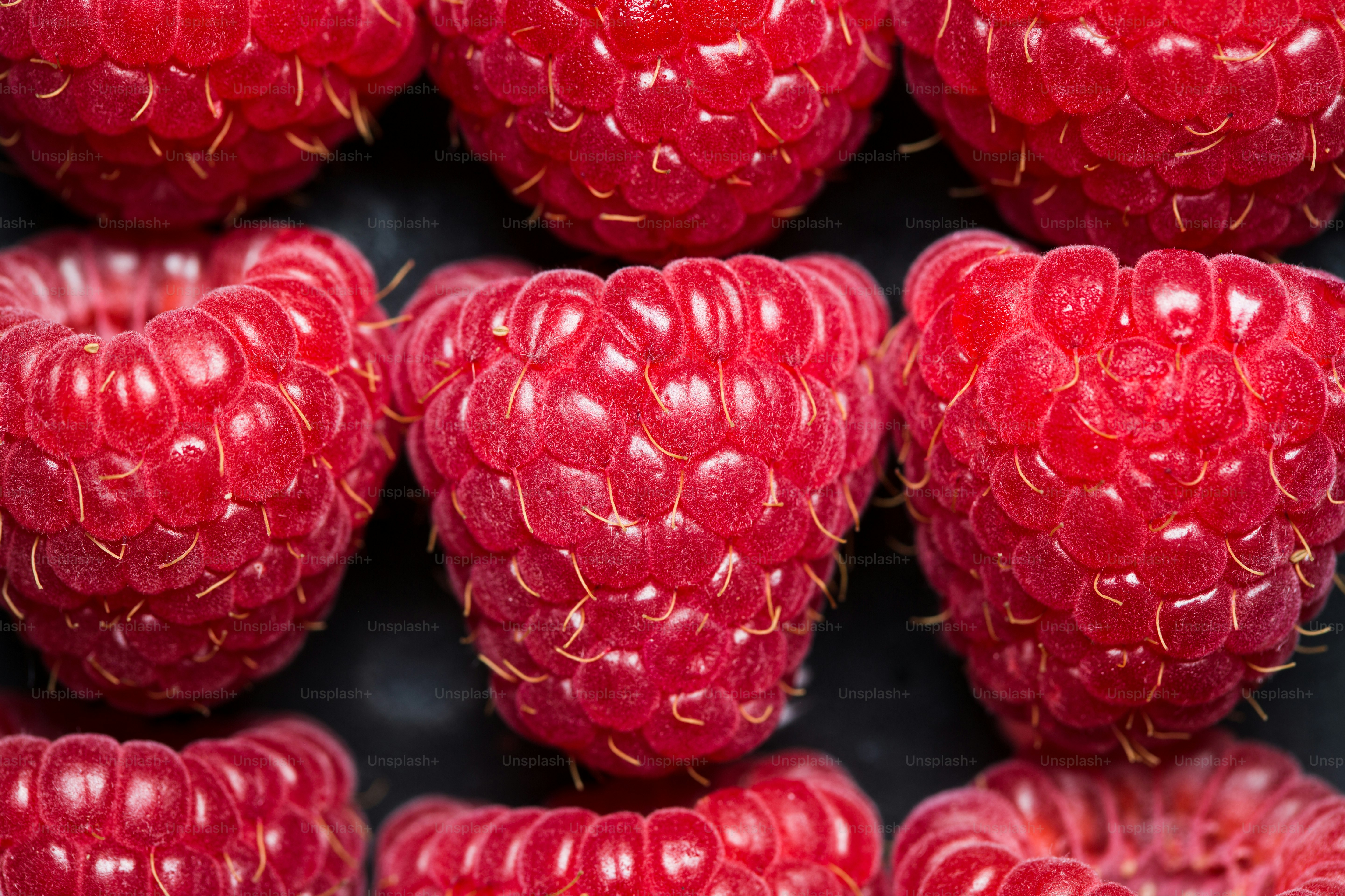 A pile of red raspberries sitting on top of each other