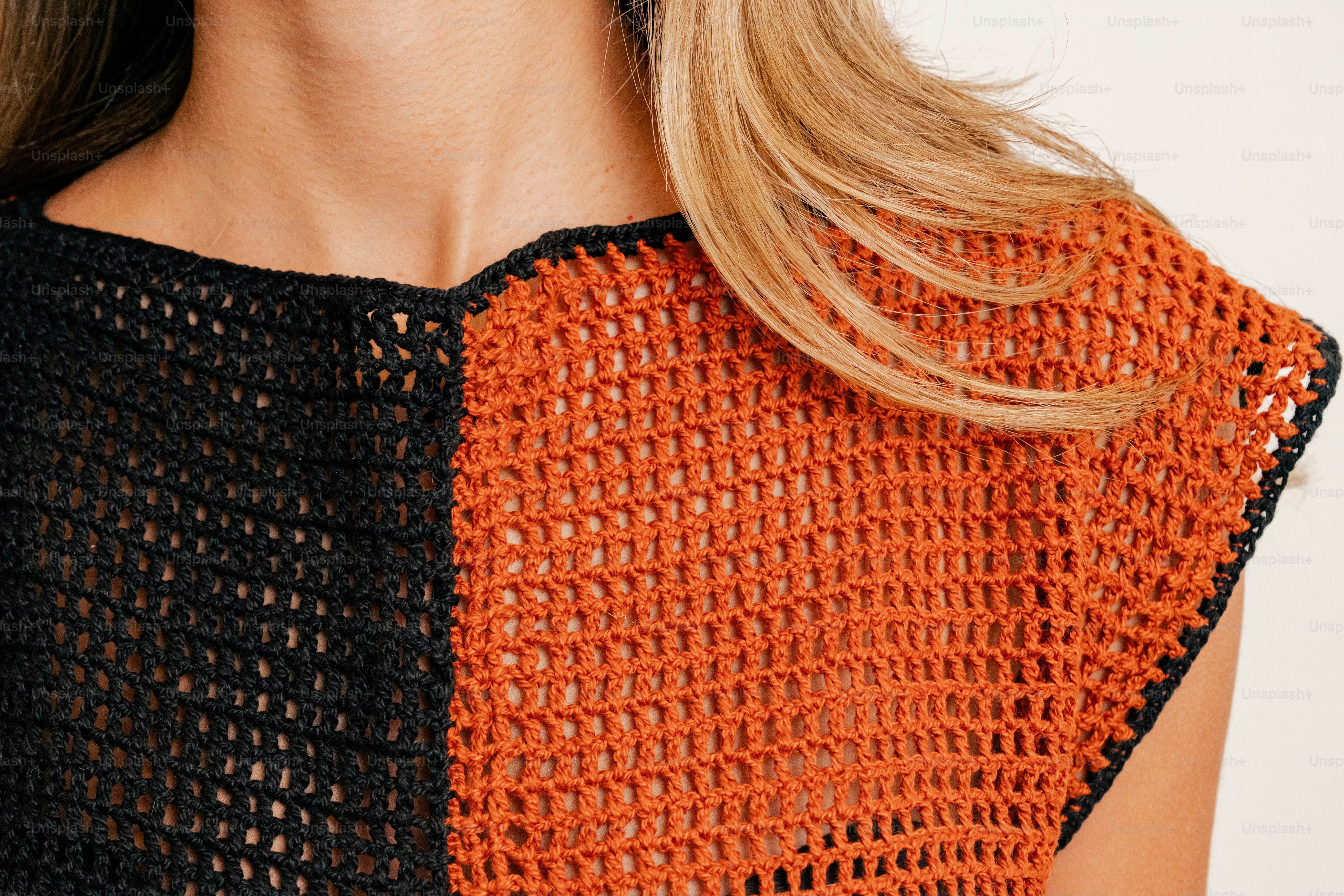 A close up of a woman wearing an orange and black top