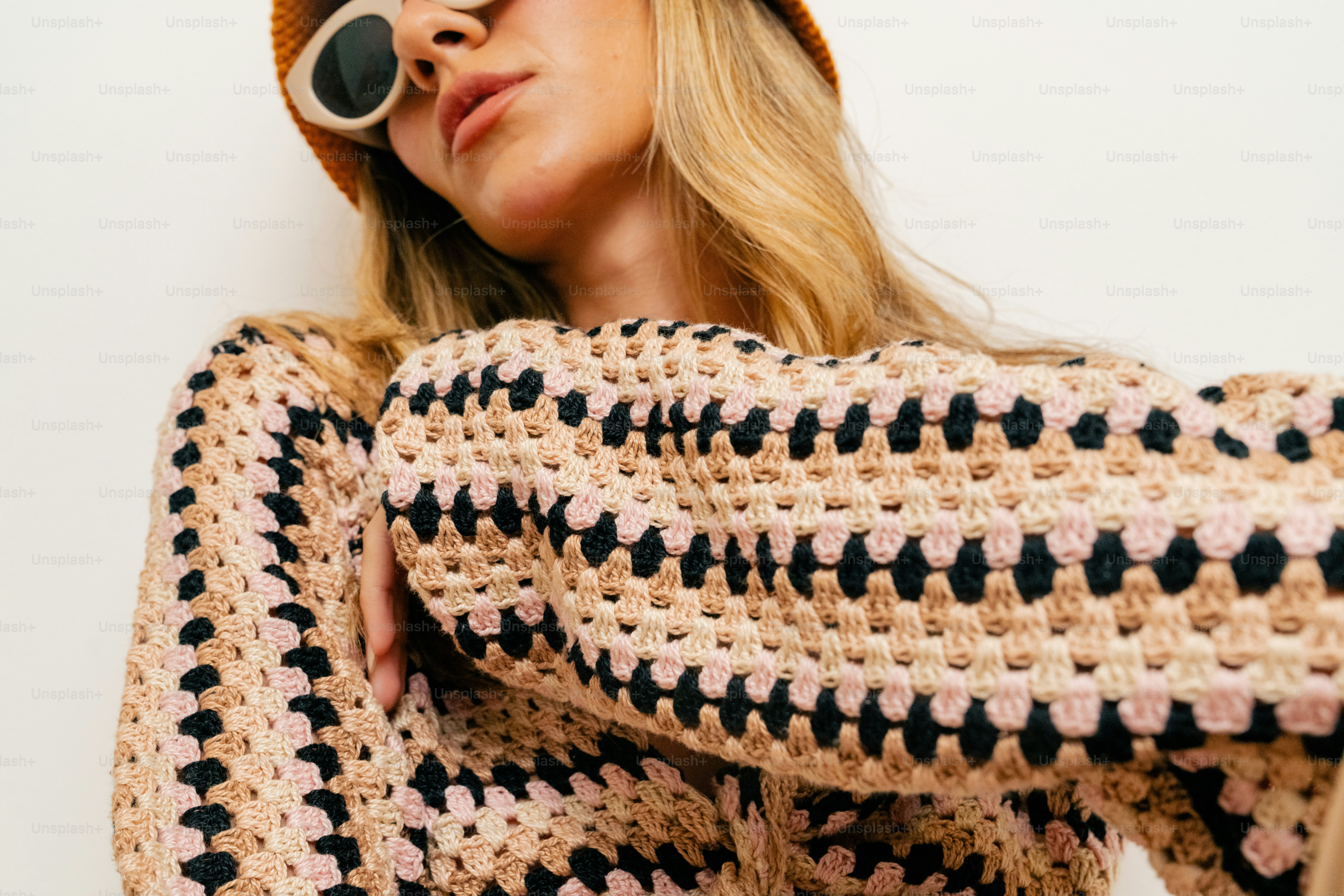 A woman wearing a crochet sweater and a hat