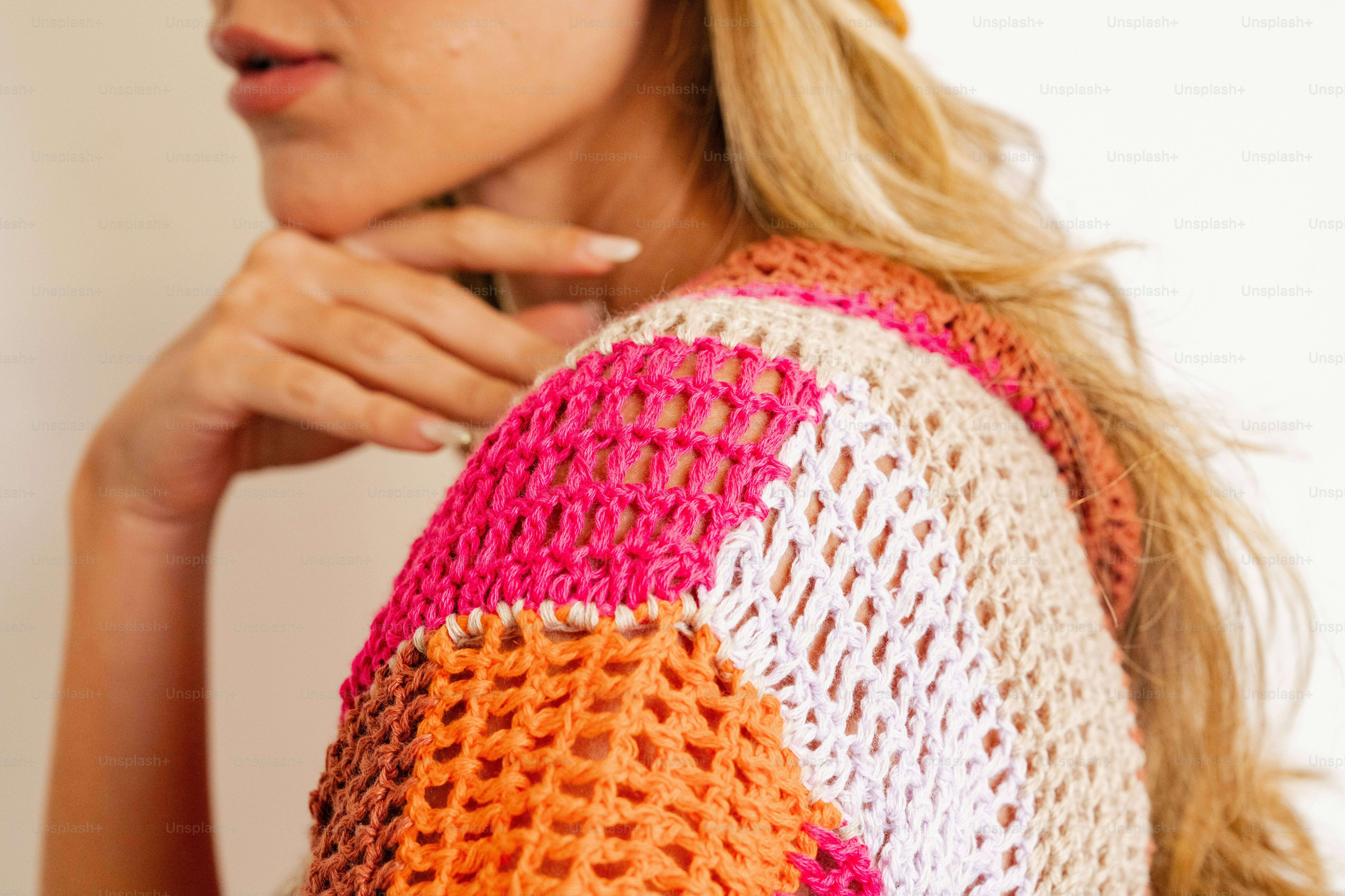 A woman wearing a colorful crochet sweater