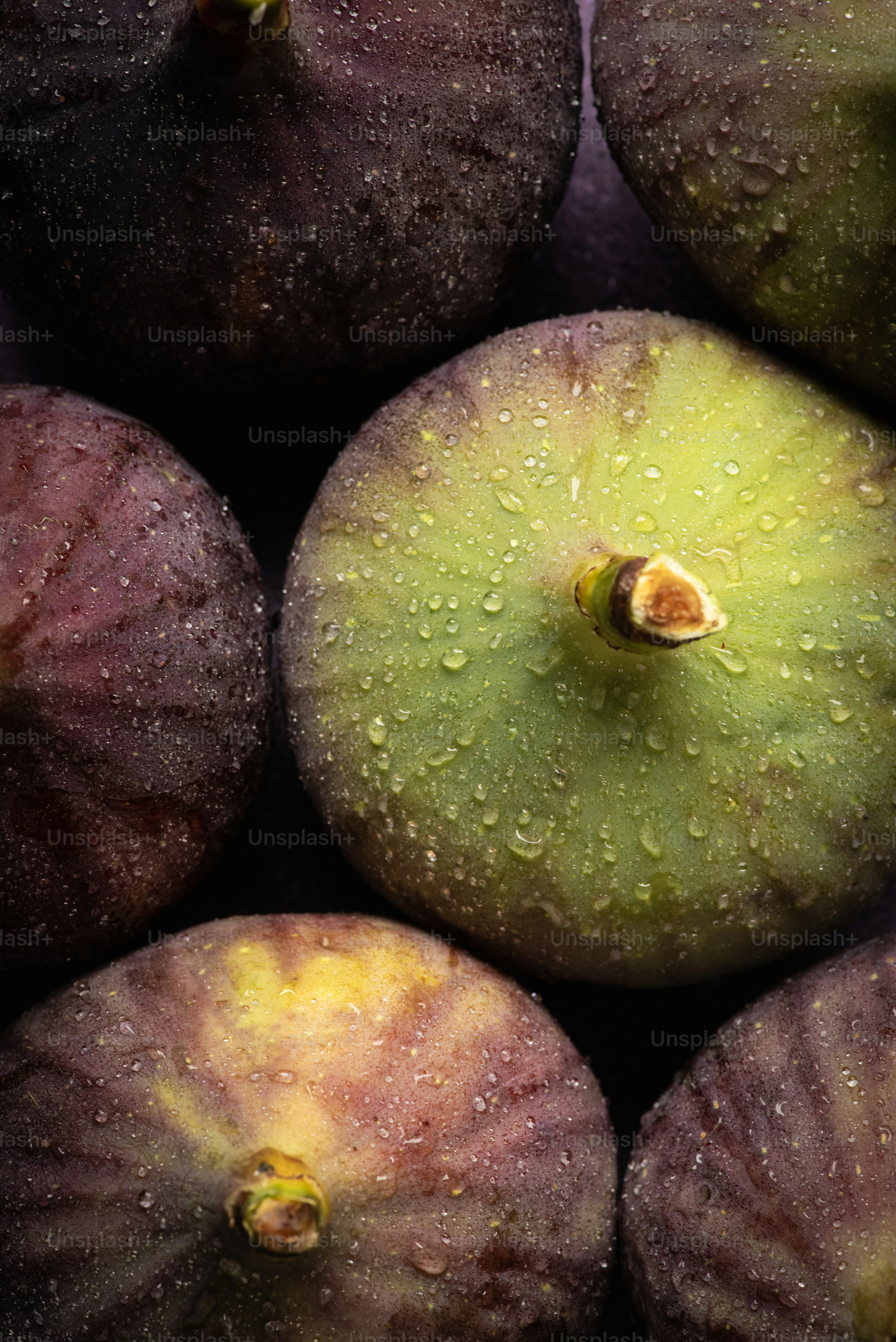 Uma pilha de ameixas com gotas de água sobre elas