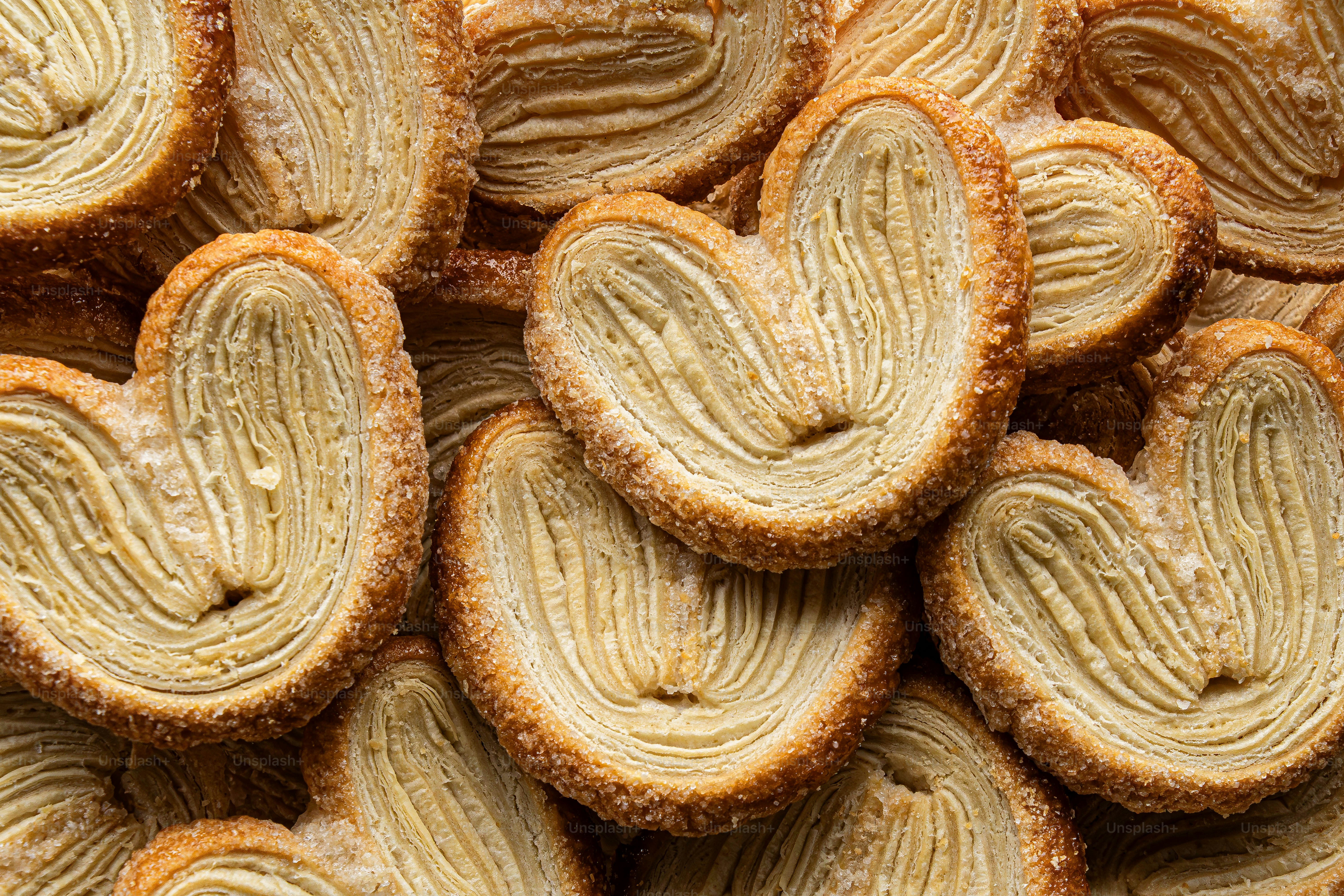 A pile of heart shaped cookies sitting on top of a table