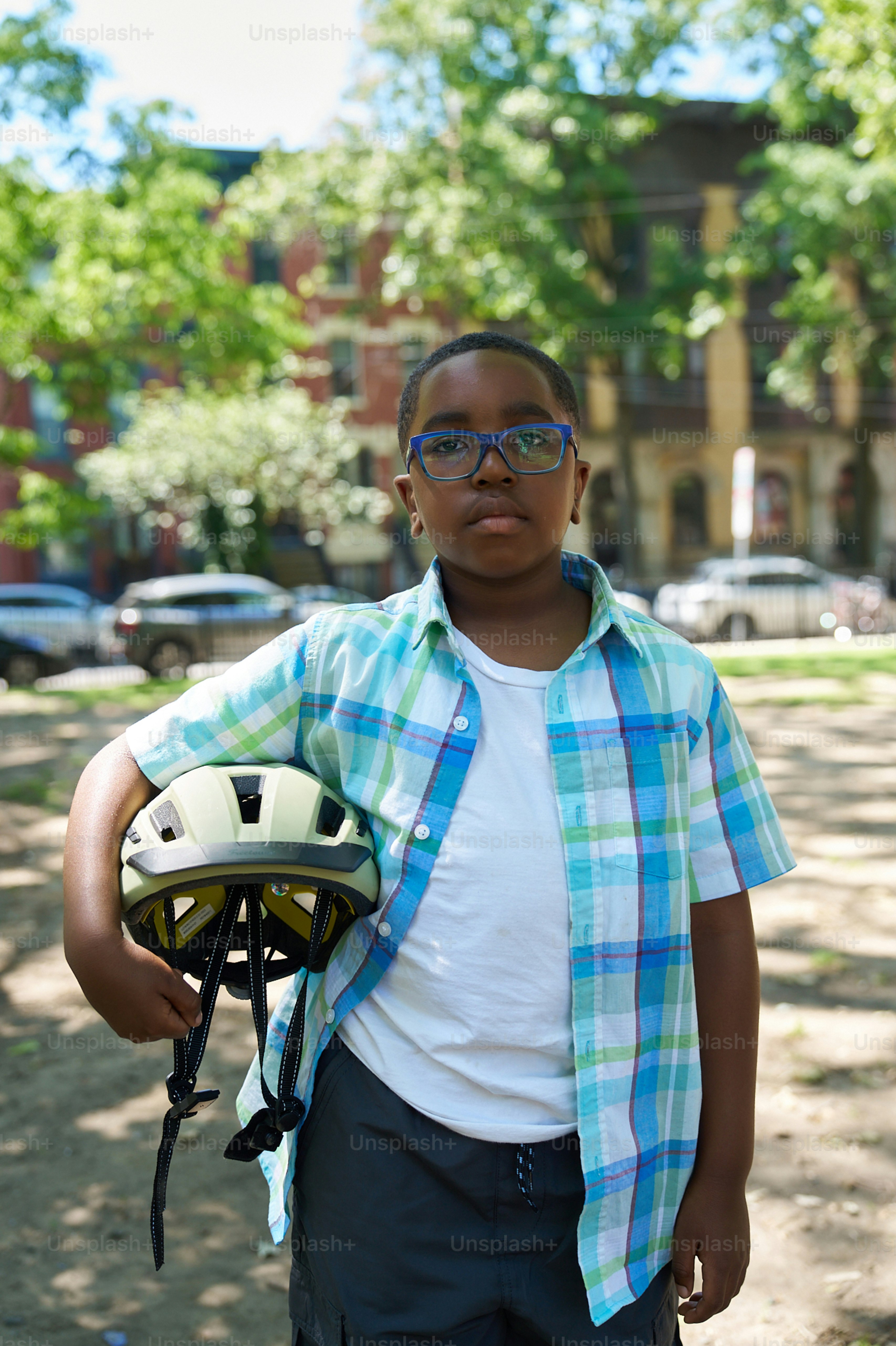 A young boy holding a helmet and a bike helmet