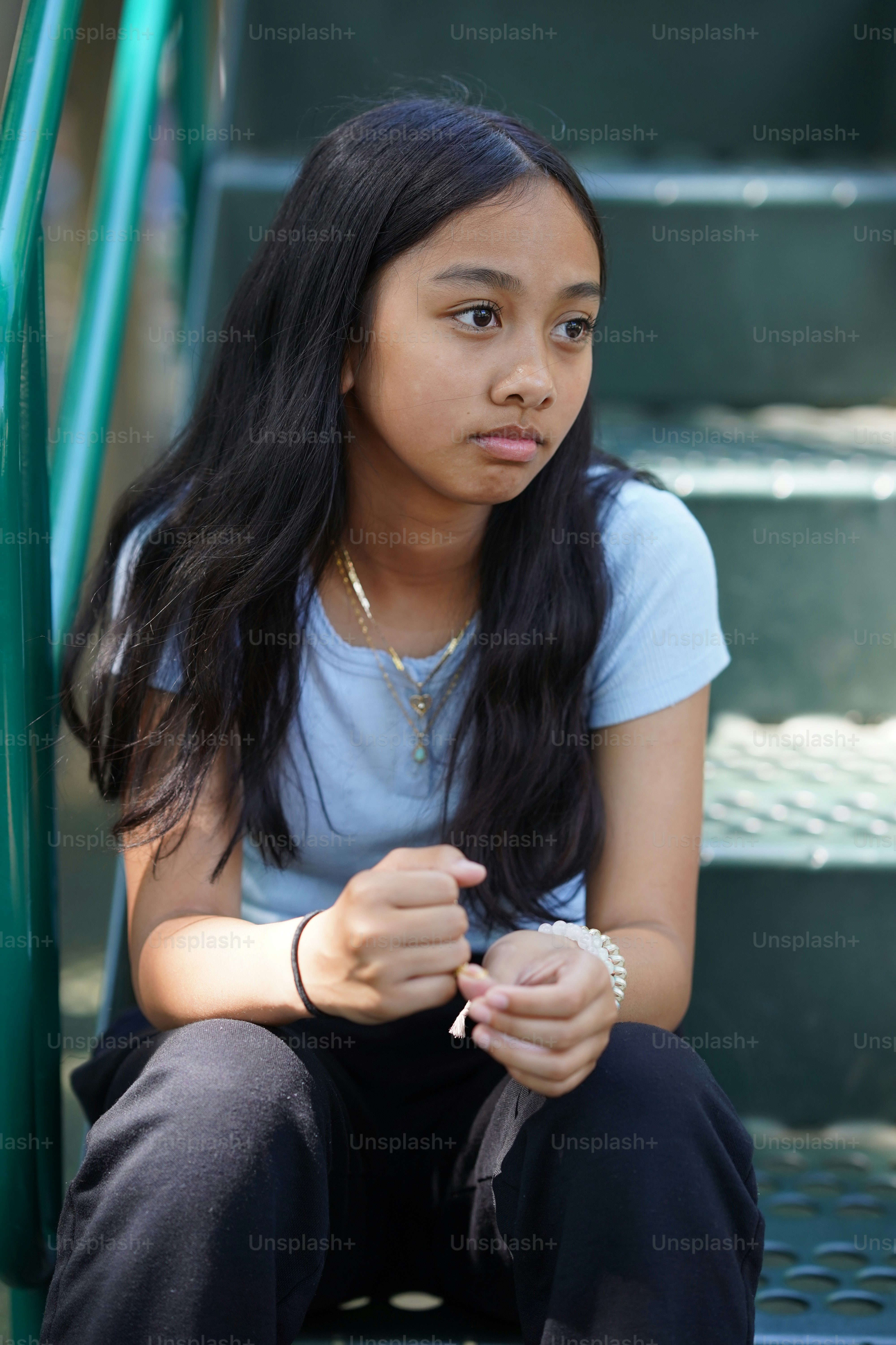 A young girl sitting on a set of stairs