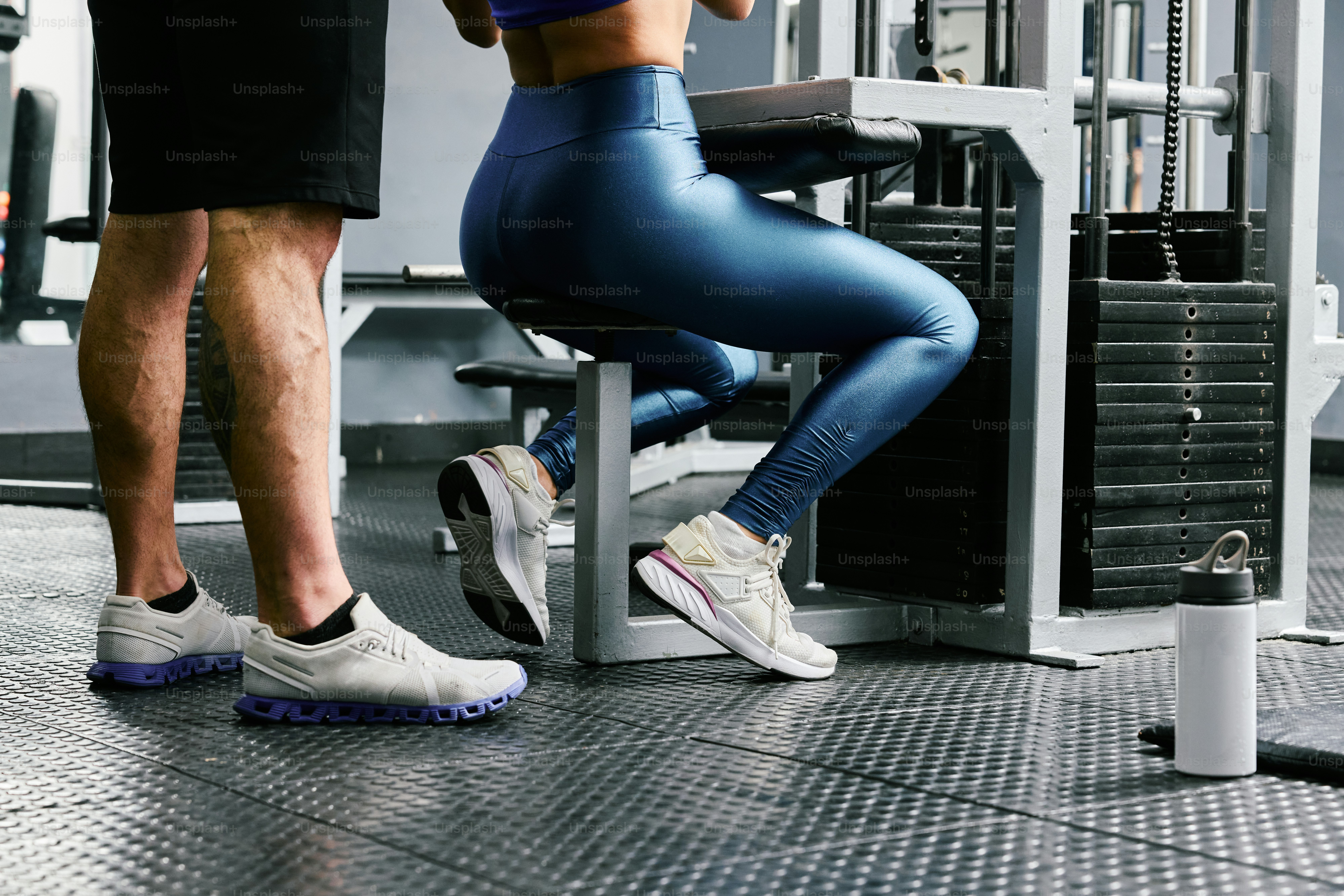 A man and a woman doing squats in a gym