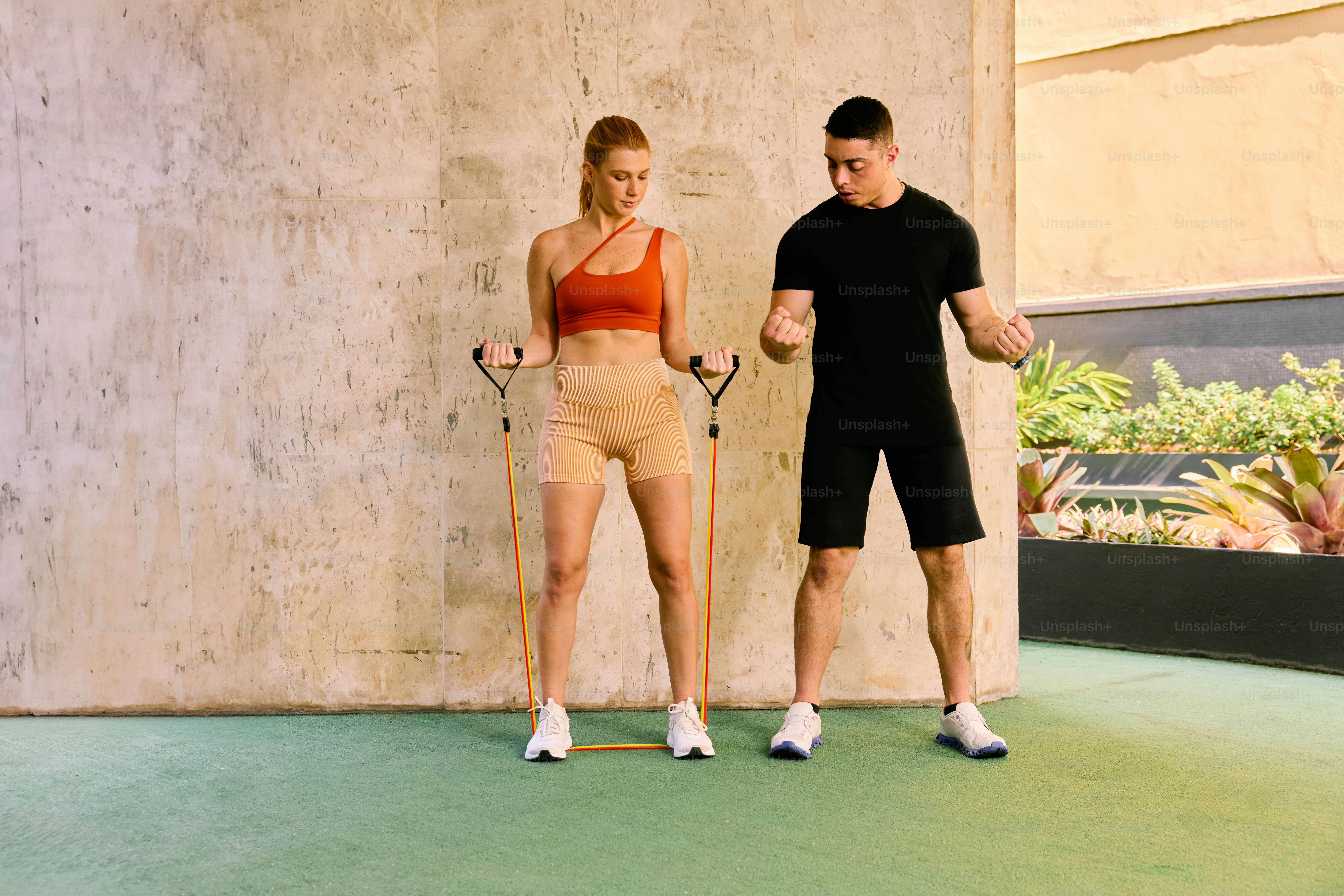 Un hombre de pie junto a una mujer que sostiene una raqueta de tenis