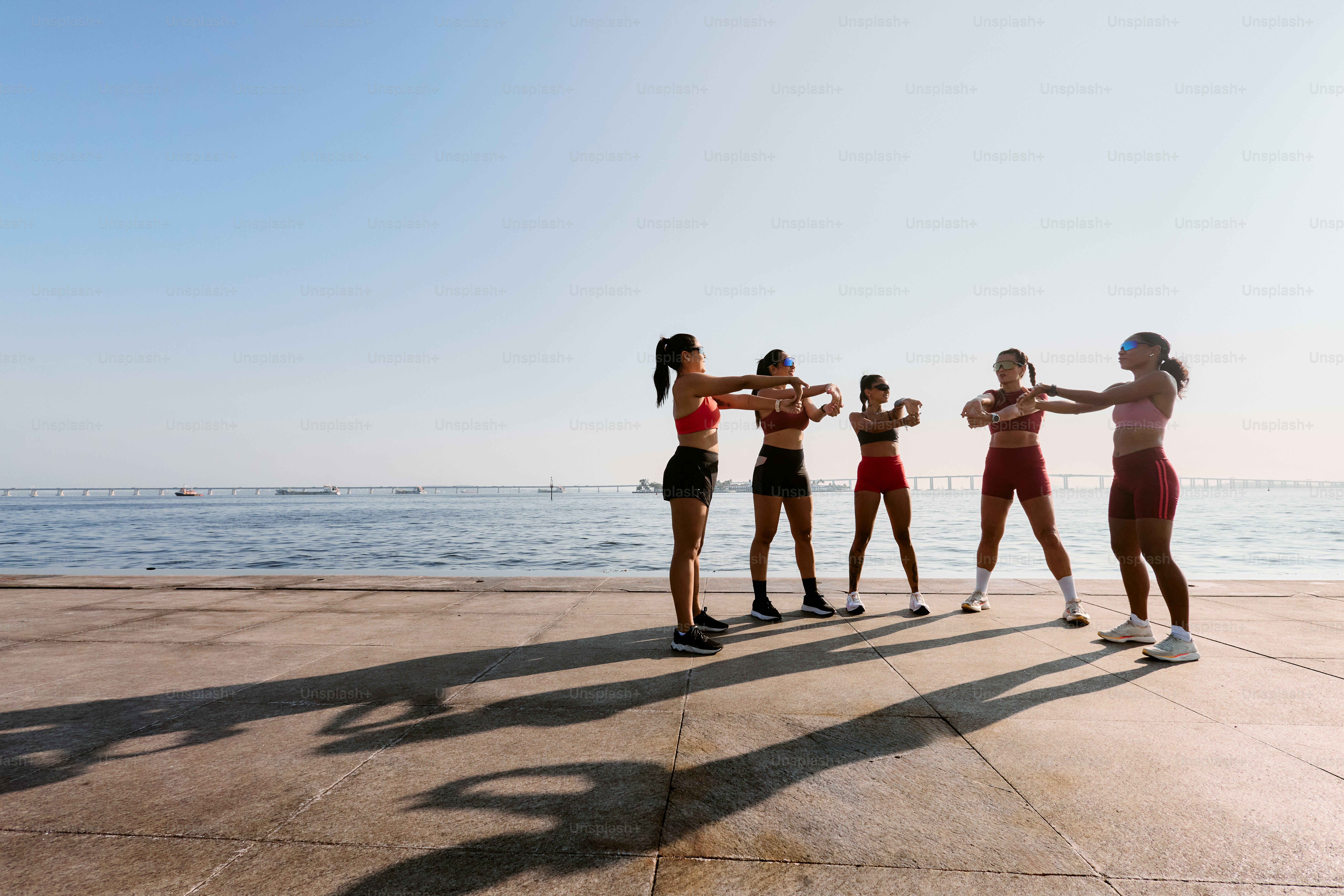 A group of women standing next to each other on a beach