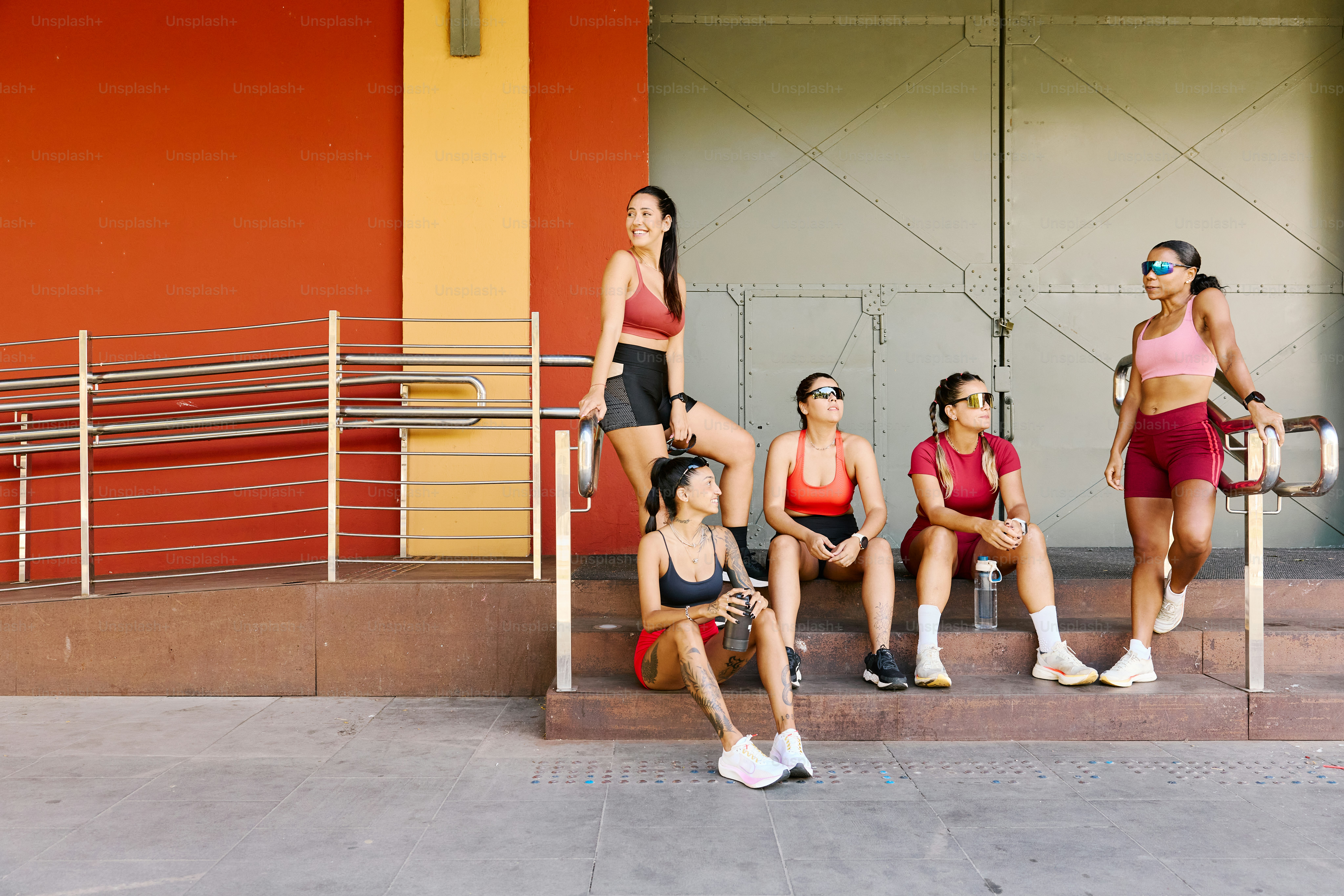 A group of women sitting on a bench in front of a building
