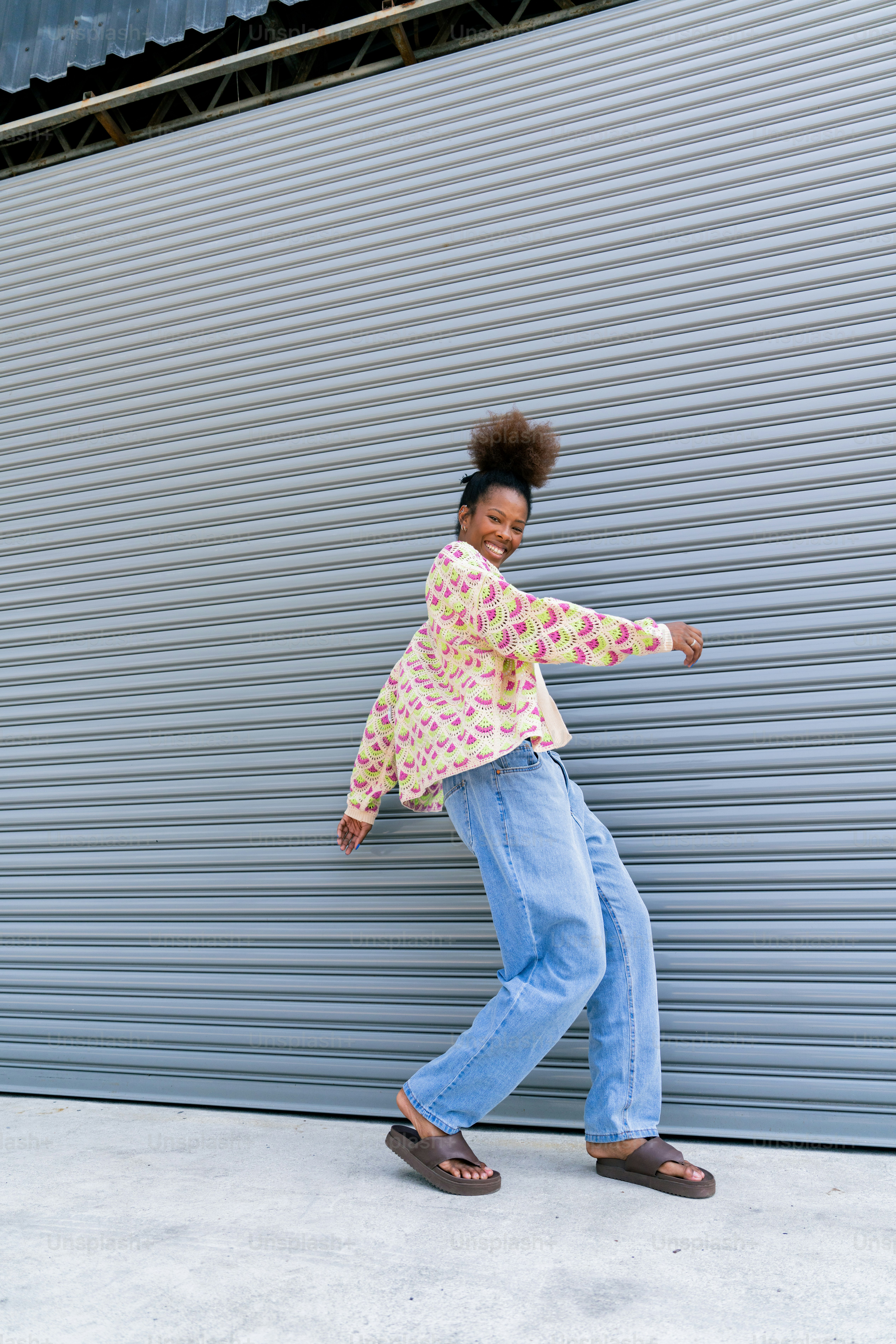 A woman standing in front of a metal wall