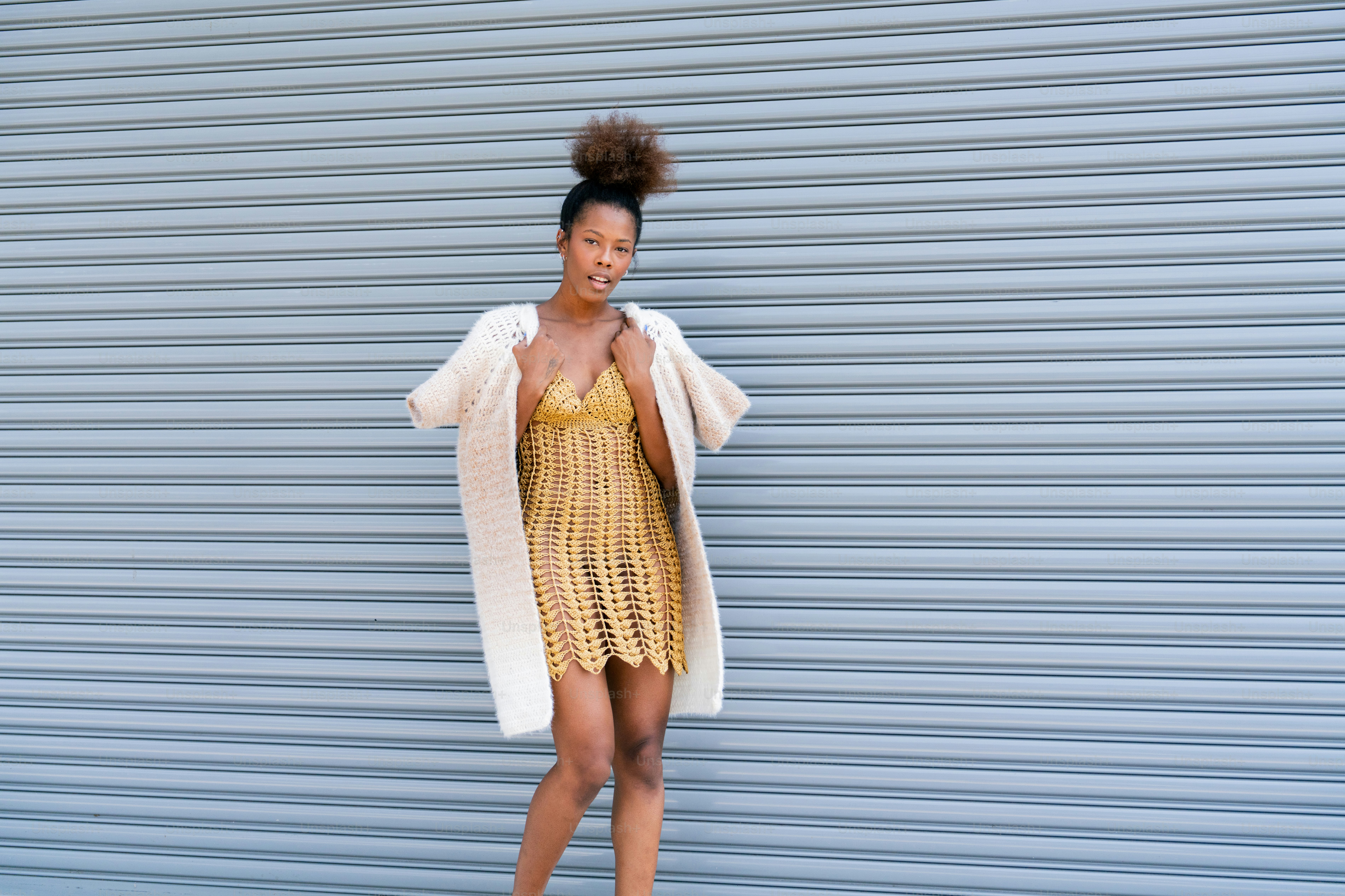 A woman standing in front of a blue wall photo – Fashion model Image on ...