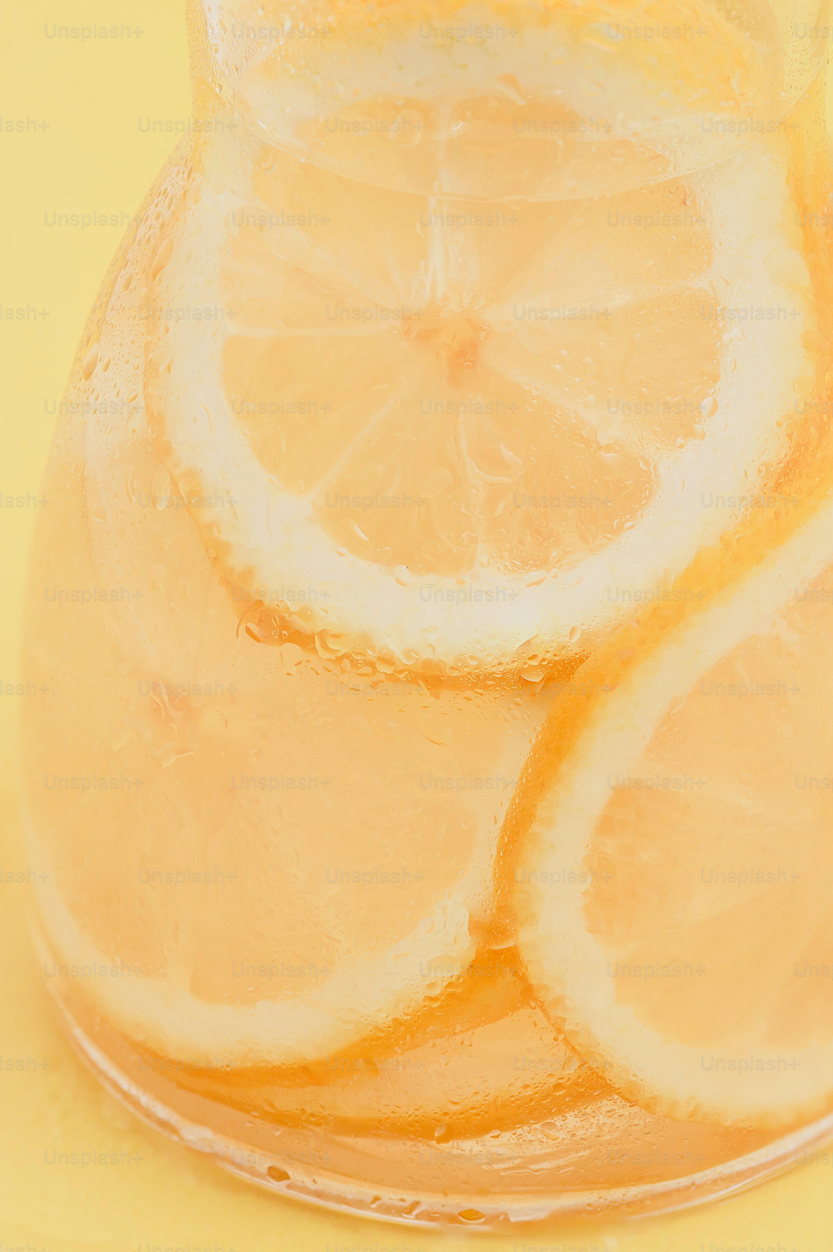 A pitcher filled with lemons sitting on top of a table