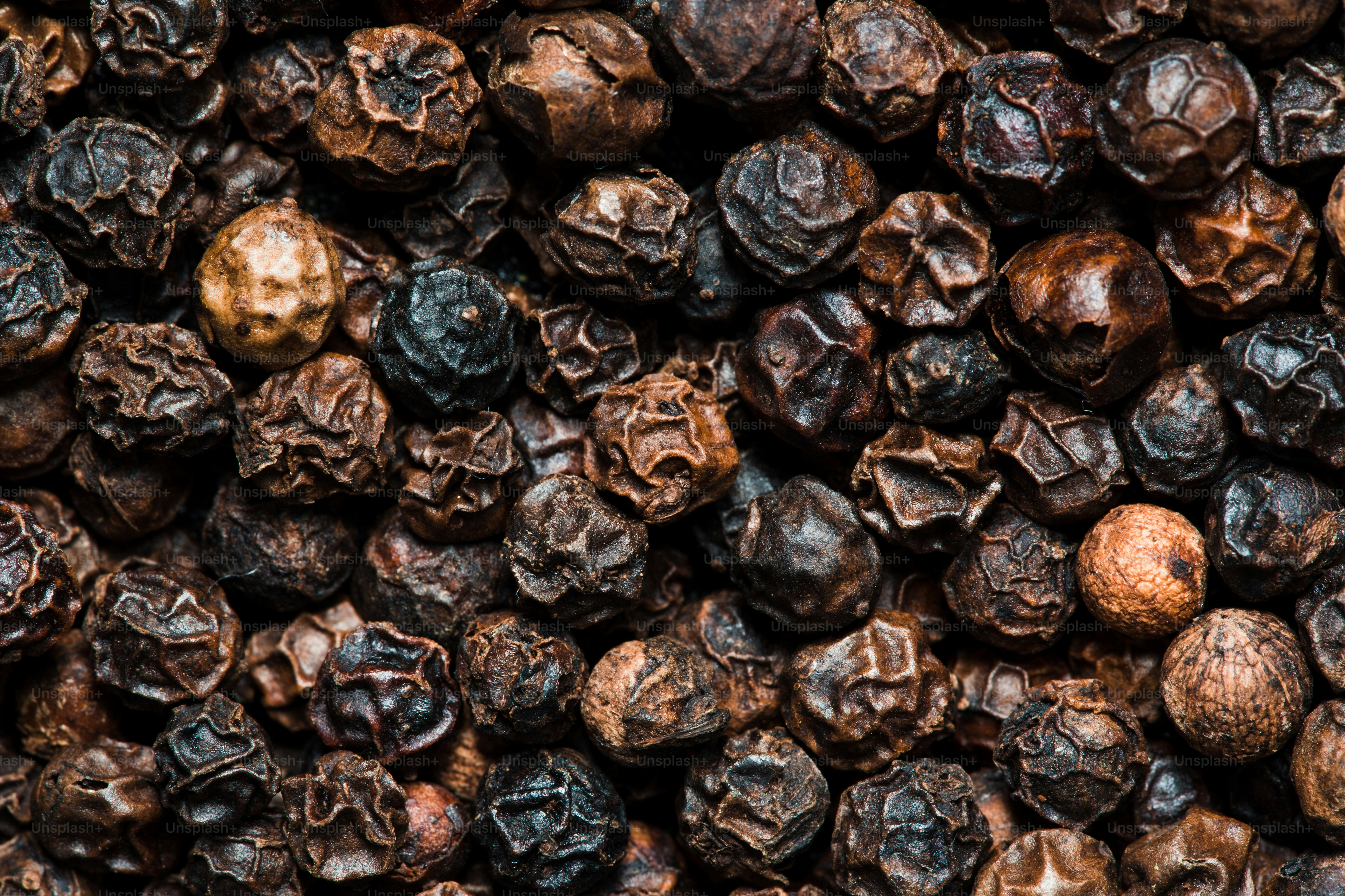 A close up of a pile of black pepper